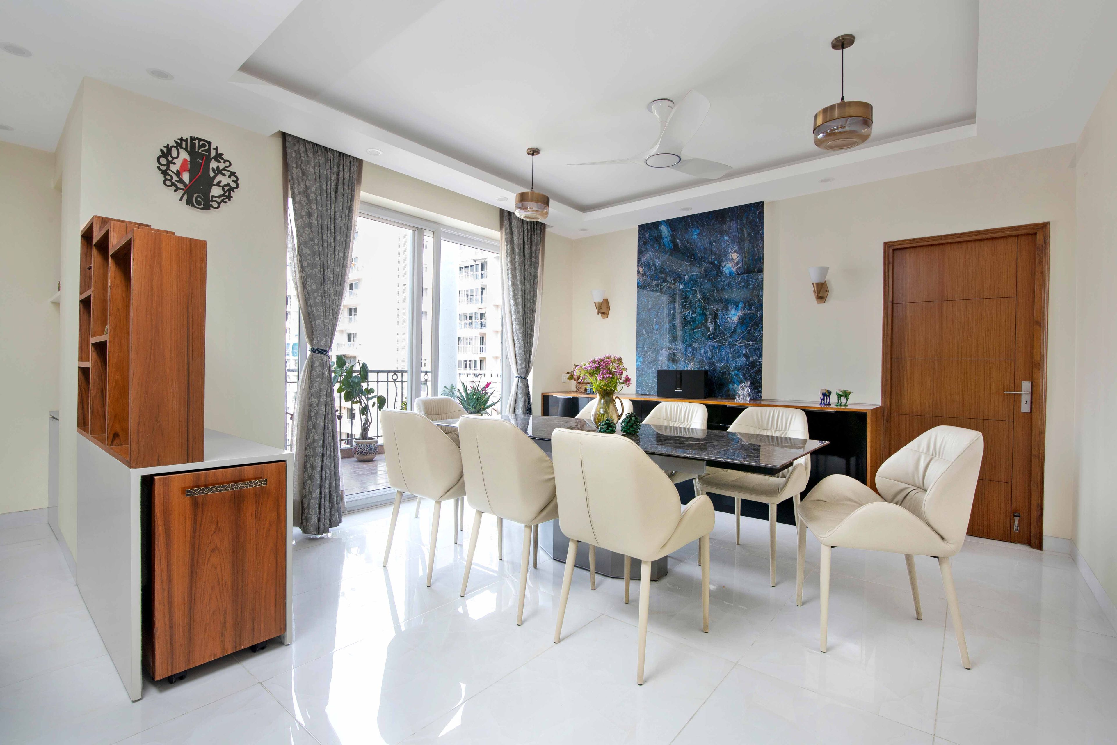 8-Seater Dining Room With Cream Wall Paint And Blue Marble Panelling - Livspace