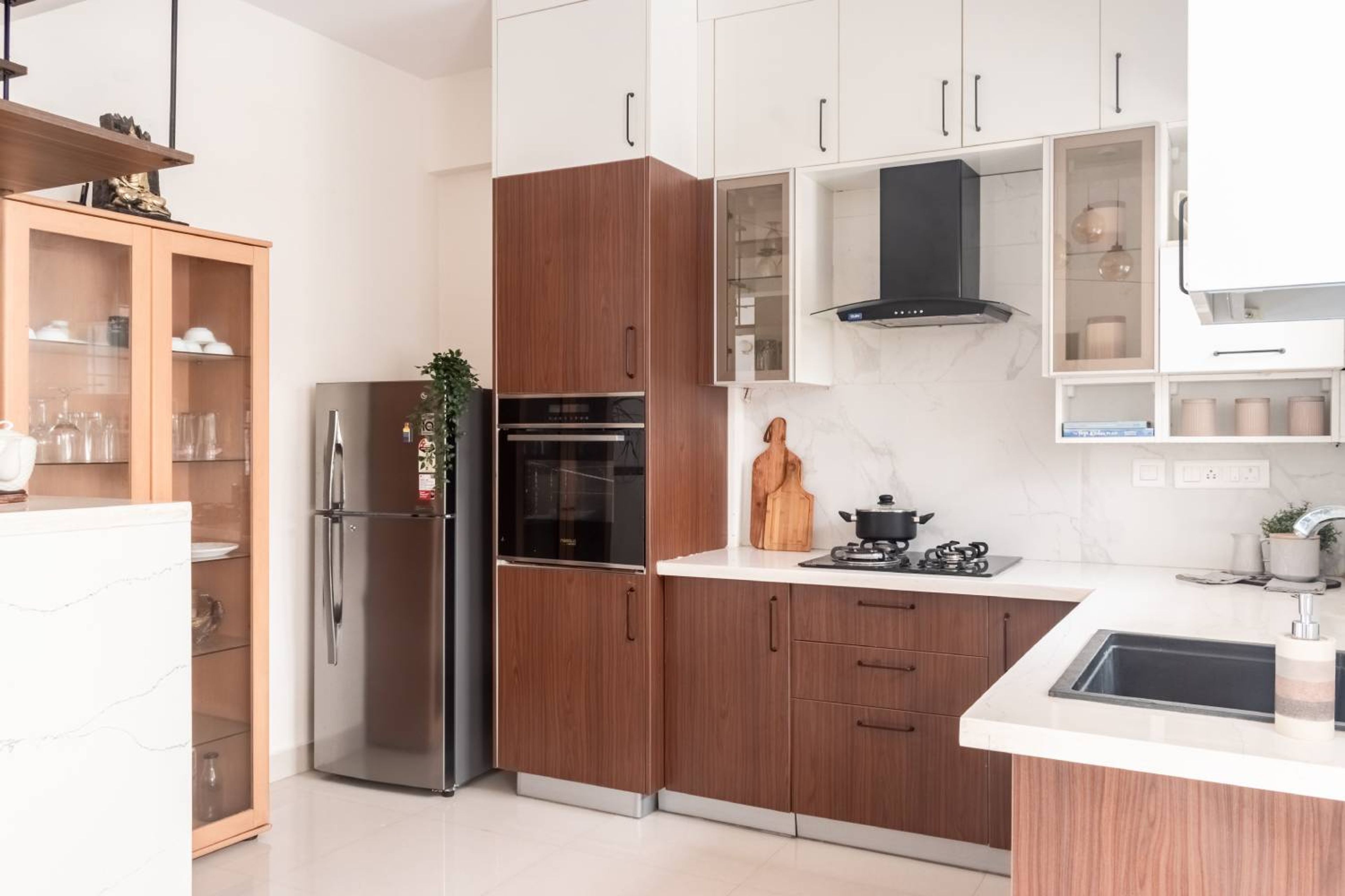 L-Shaped Modular Kitchen Design with Glass Shutter Unit and Refrigerator