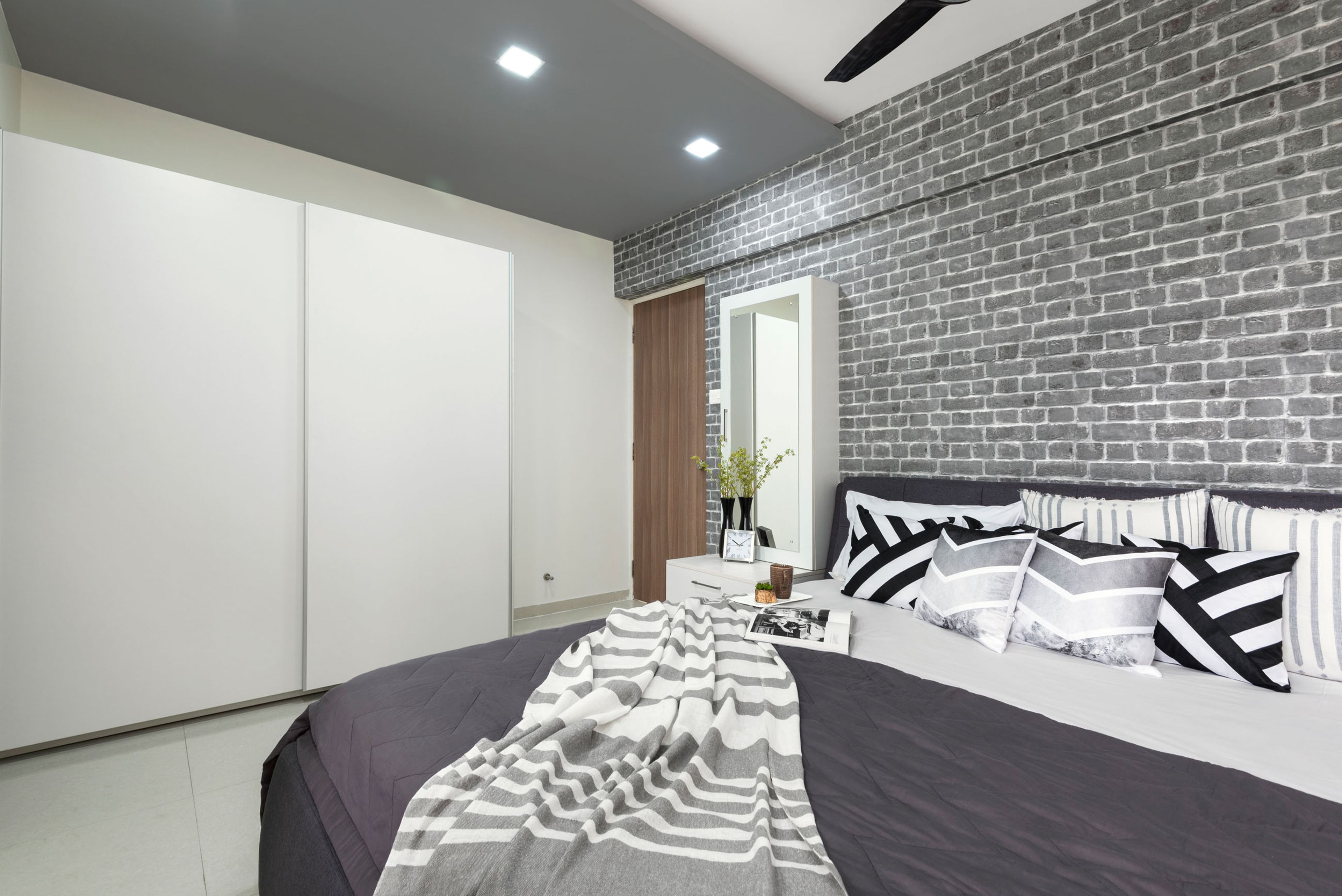 Charming Rustic Guest Room Design With Queen Bed, Grey Brick Wall, White Side Tables, and Sliding Wardrobe - Livspace