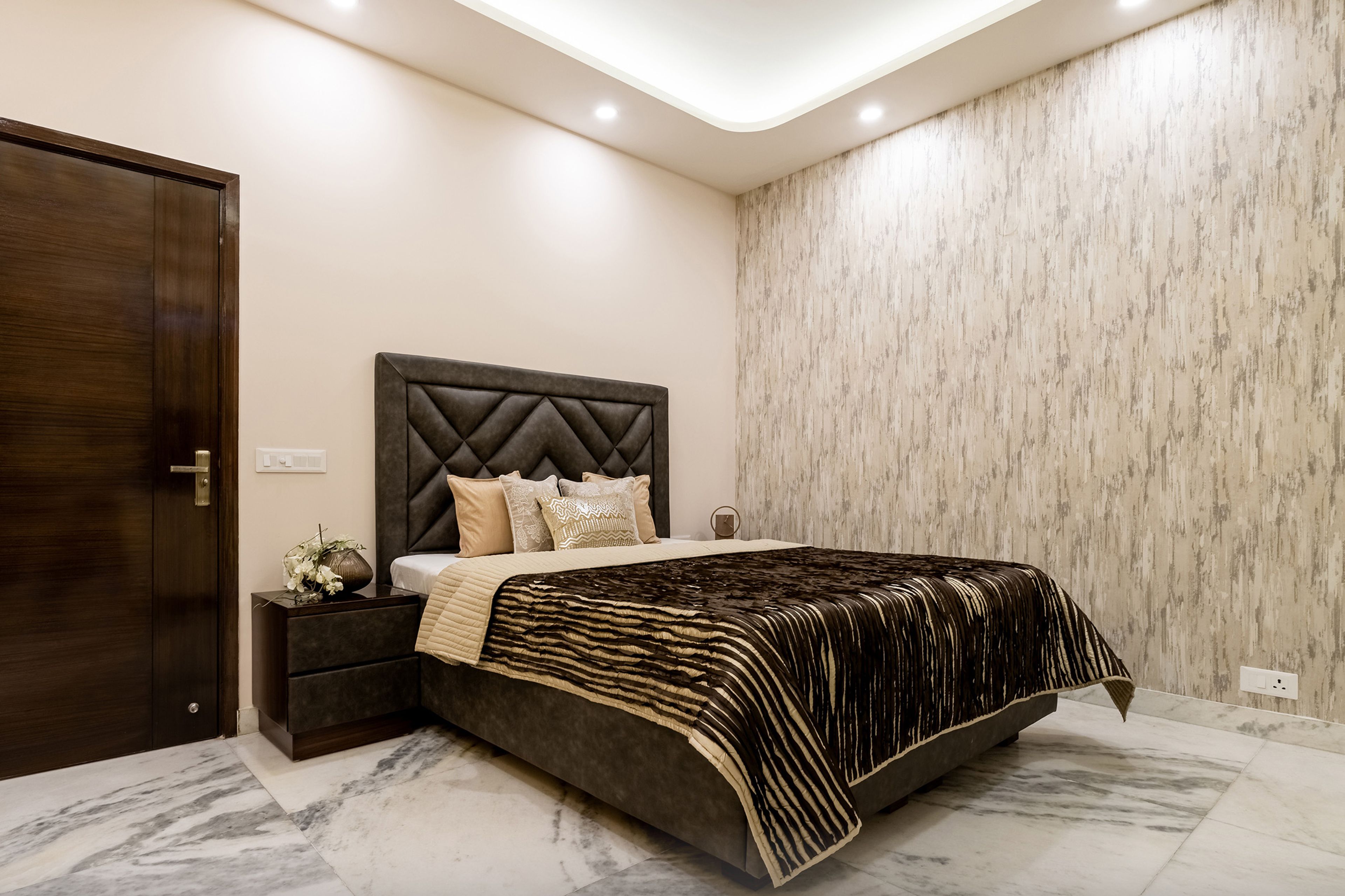 Master Bedroom With Black Upholstered Headboard And Abstract Accent Wall - Livspace