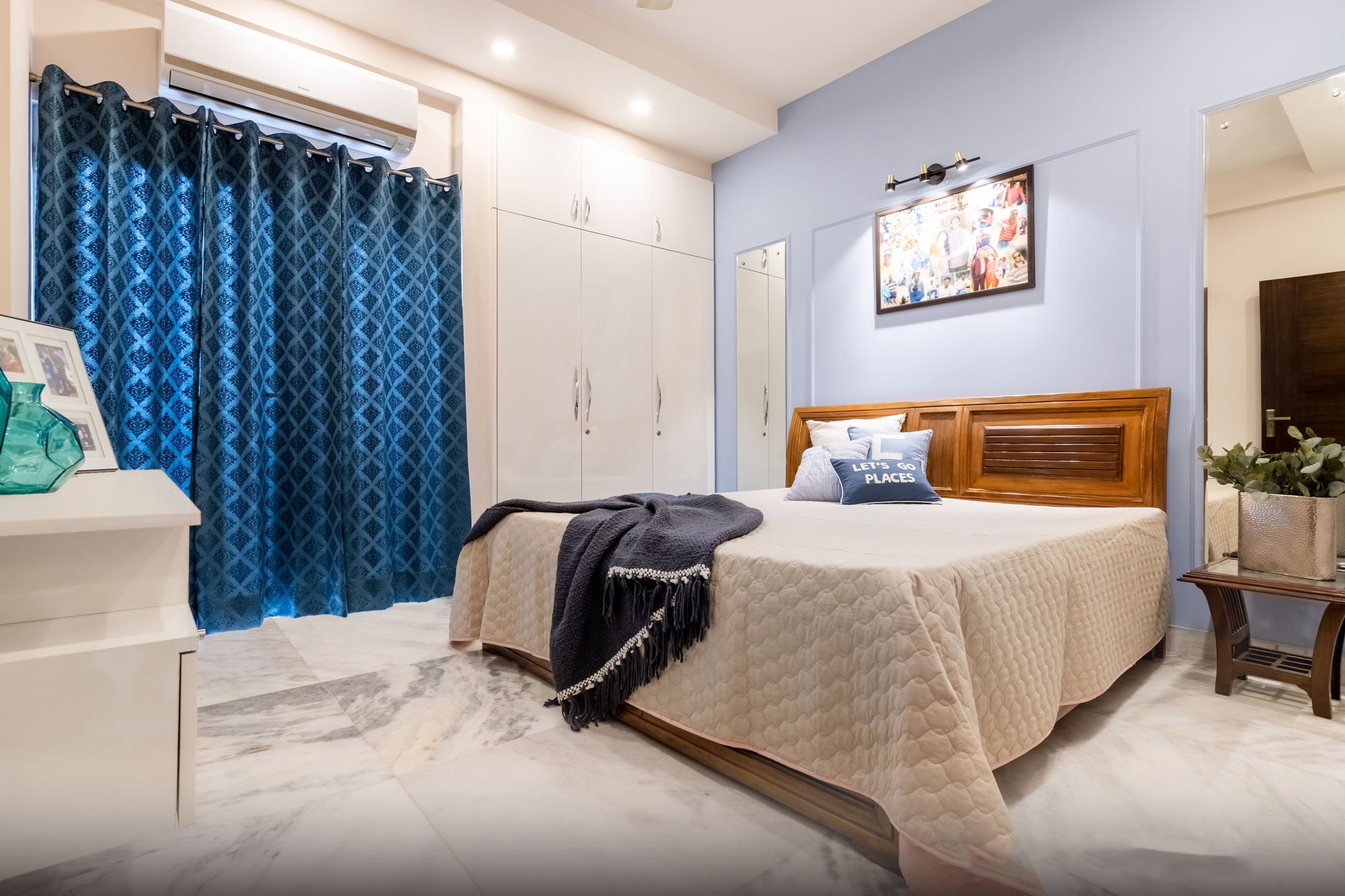 Guest Bedroom Design With Blue Accent Wall And Wooden Bed - Livspace