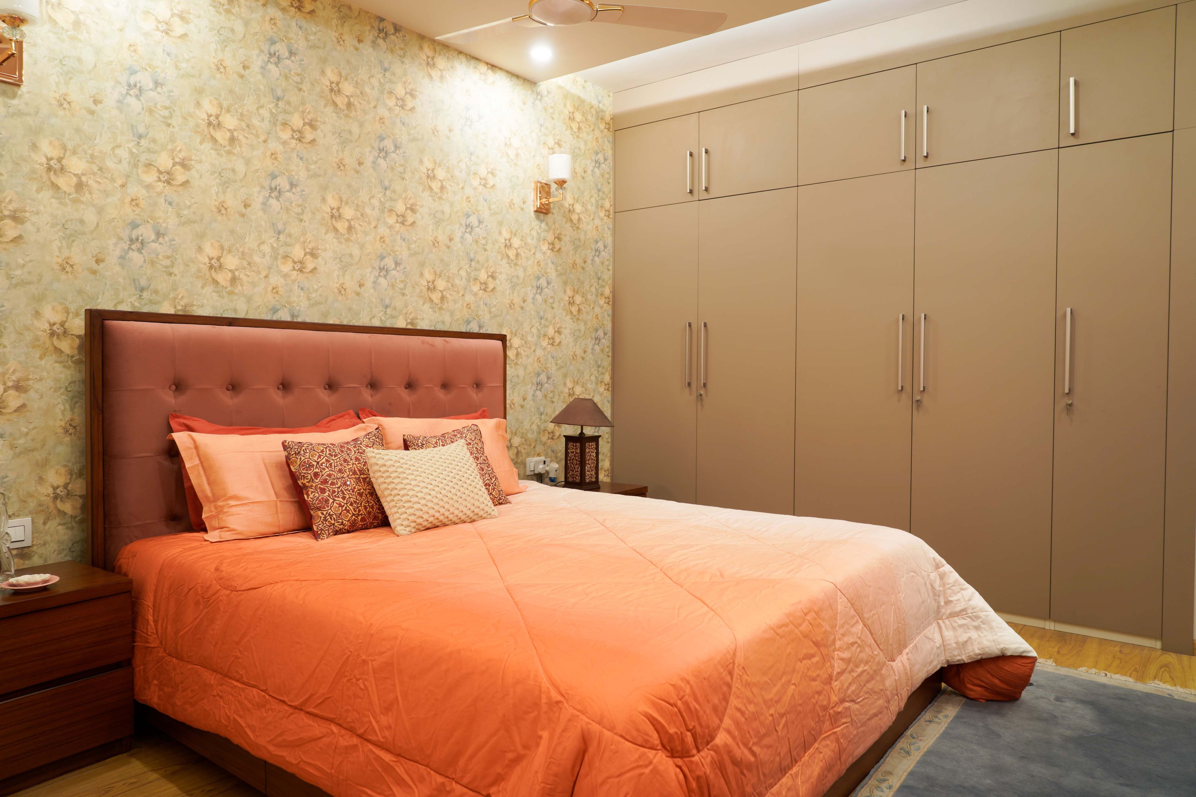 Master Bedroom With Pink Tufted Headboard And Beige Swing Wardrobe - Livspace