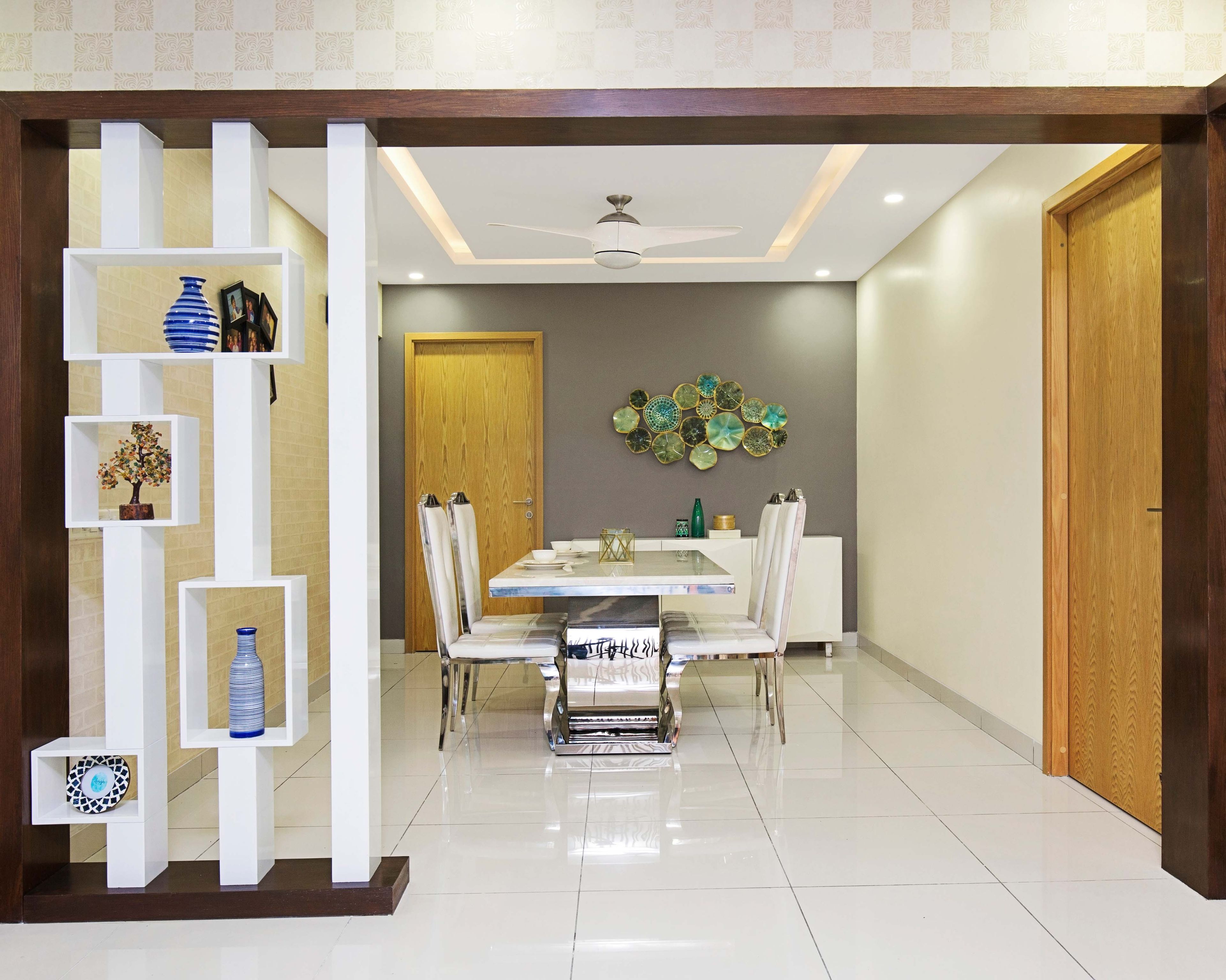 4-seater white dining room design with grey accent wall and elegant wall work - Livspace