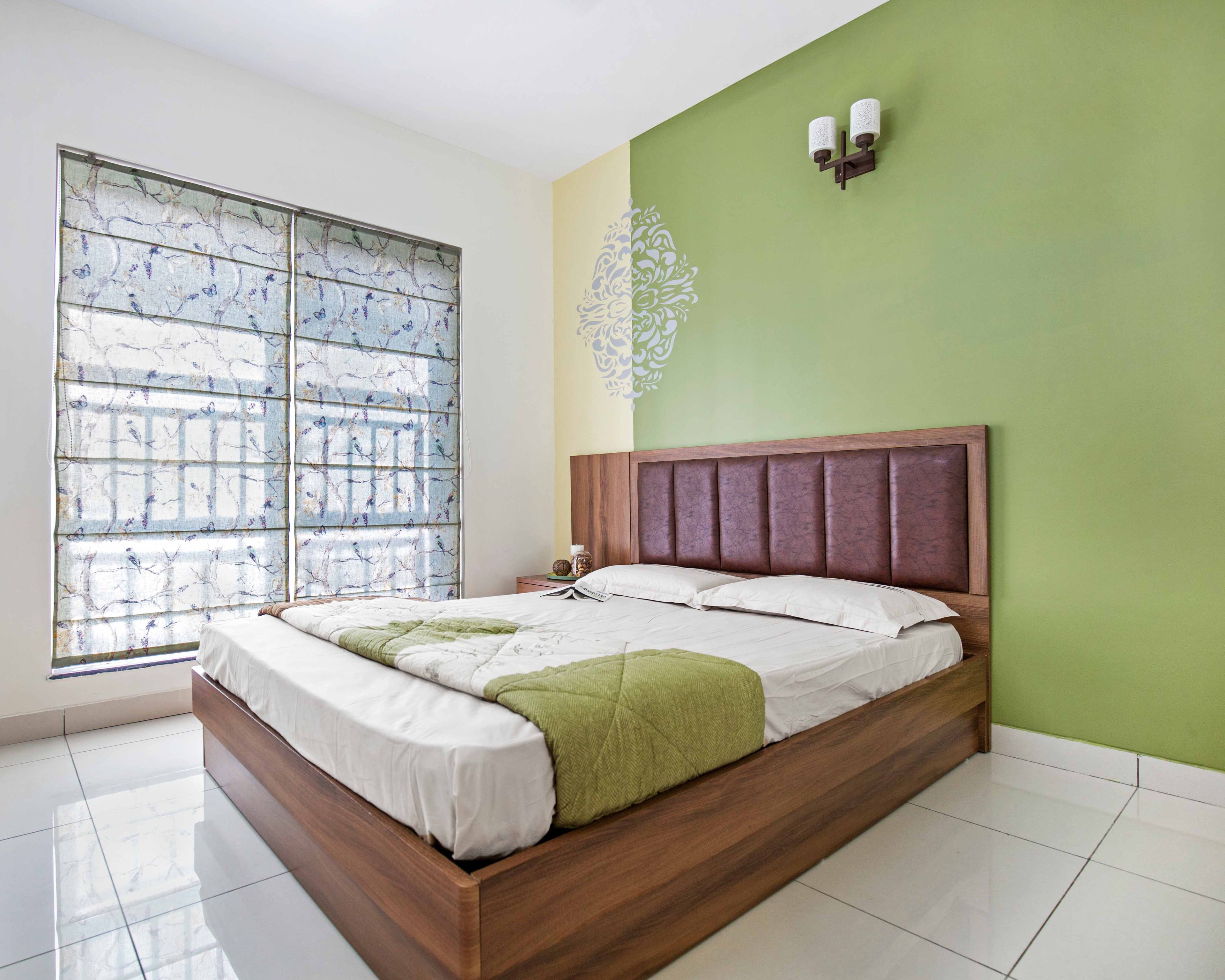 Green and wood guest room design with ornamental motif on the wall - Livspace