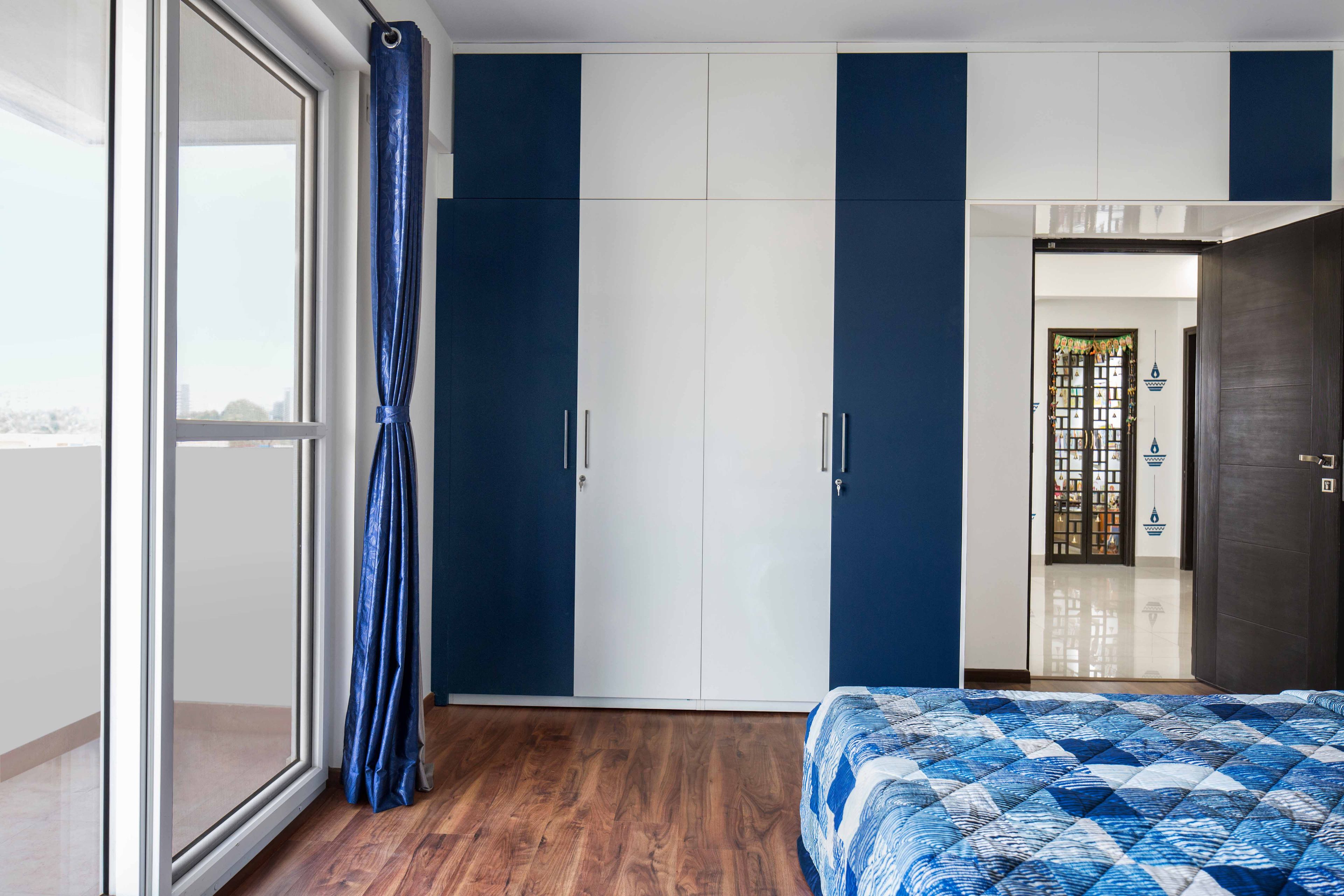 4-door blue and white swing wardrobe design with lofts - Livspace