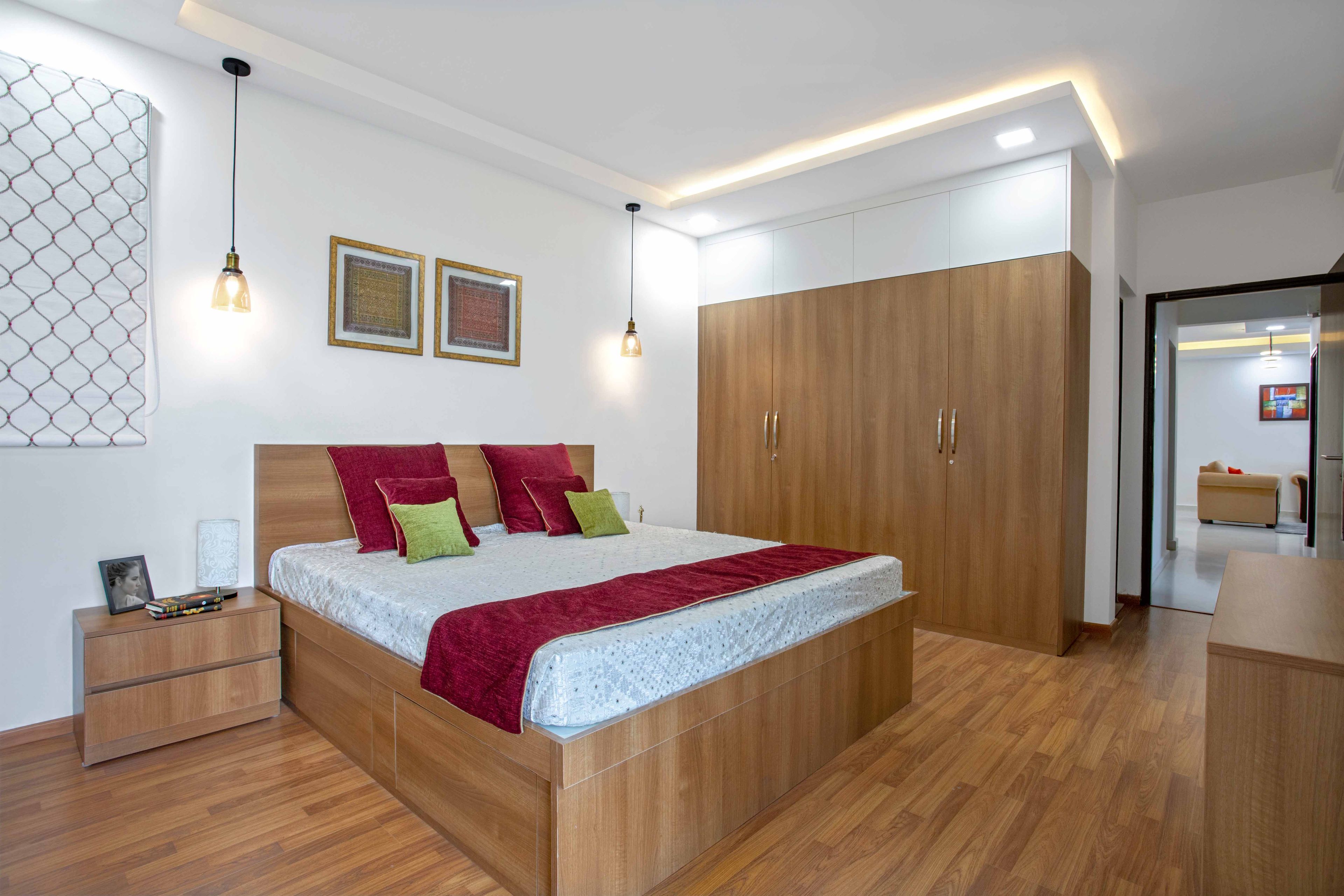 Wooden master bedroom design with wooden wardrobe and flooring - Livspace