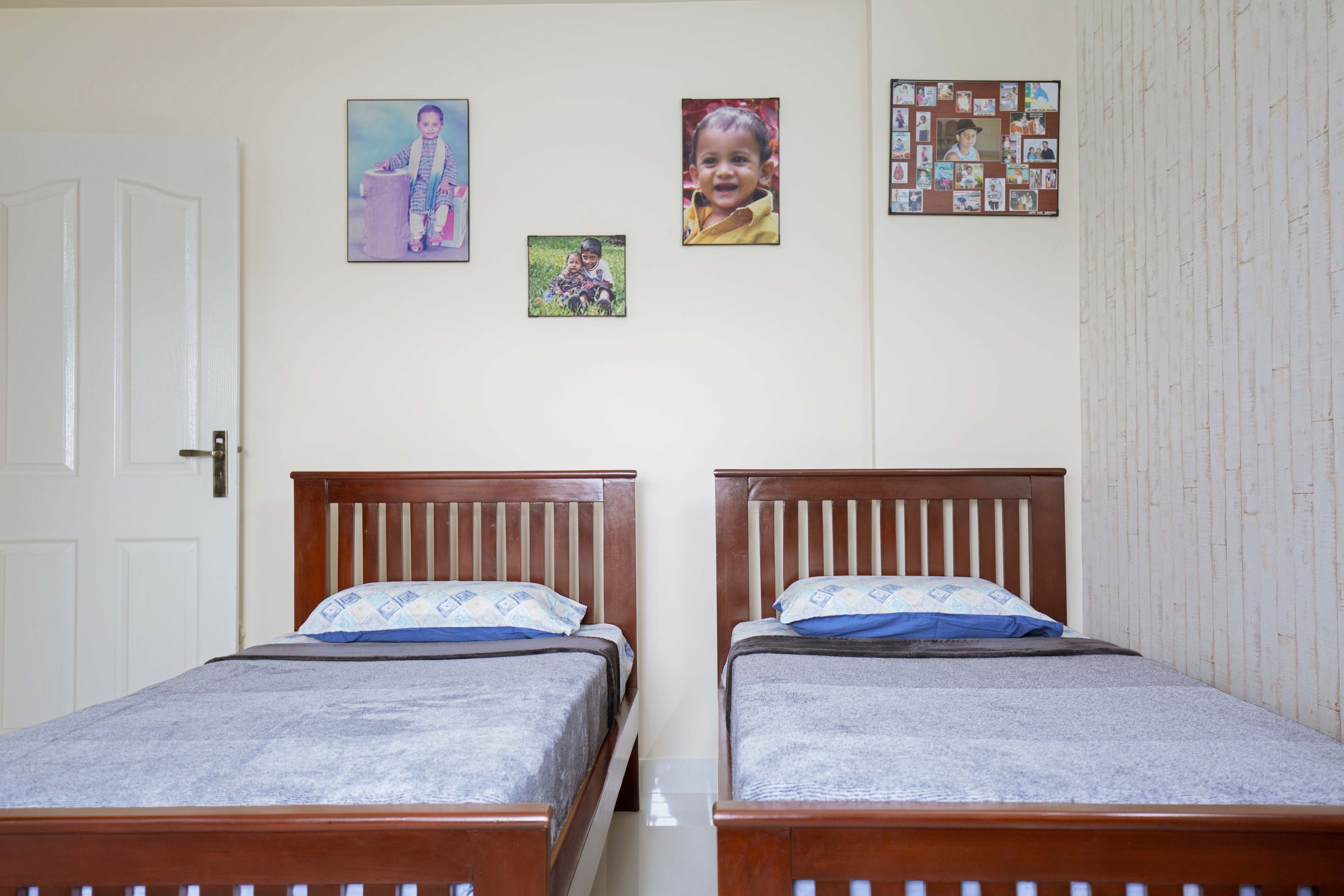 Kids room design with double wooden beds and photo frames- Livspace