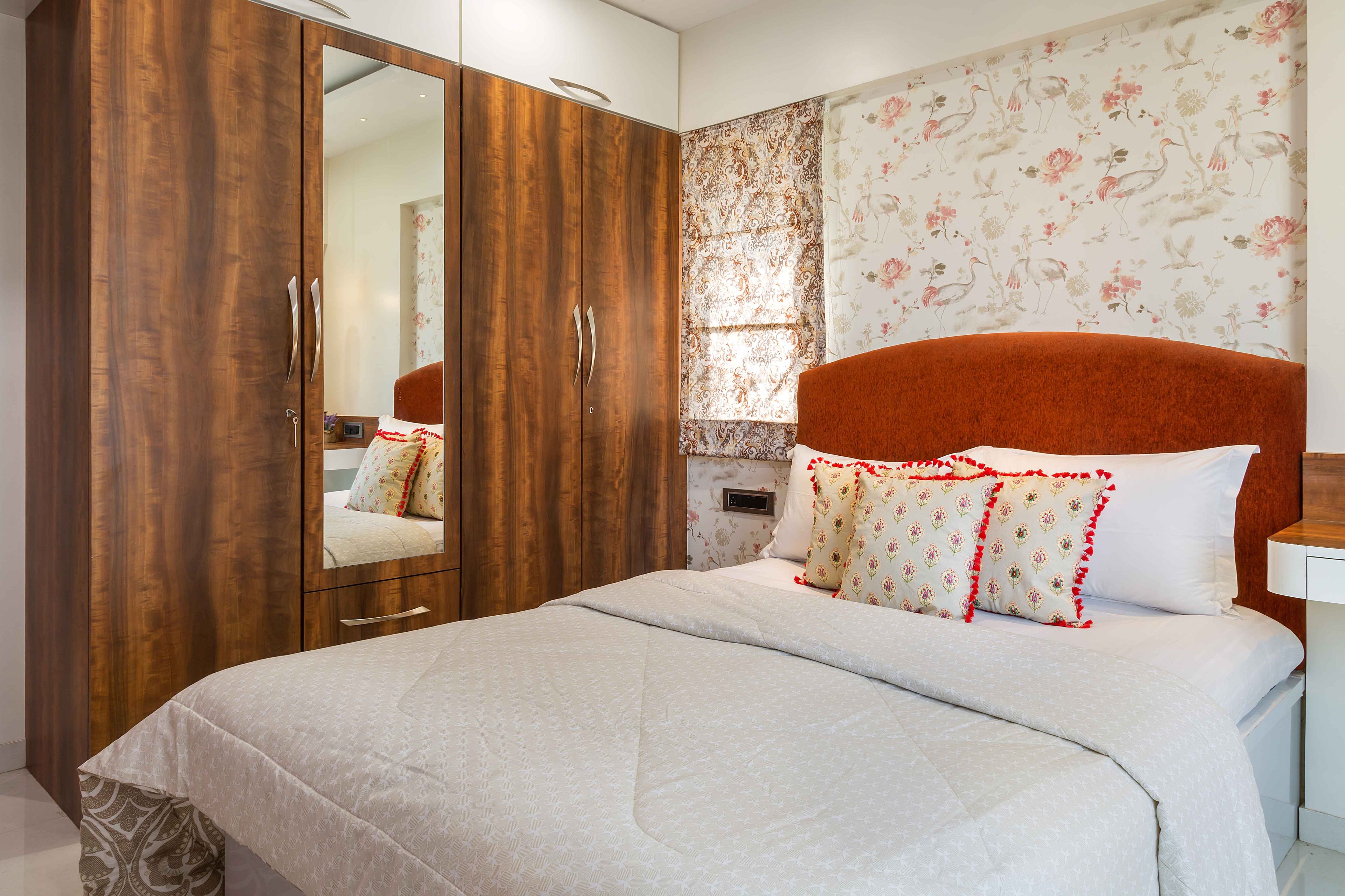 Master bedroom design with wood and white swing wardrobe and red headboard - Livspace