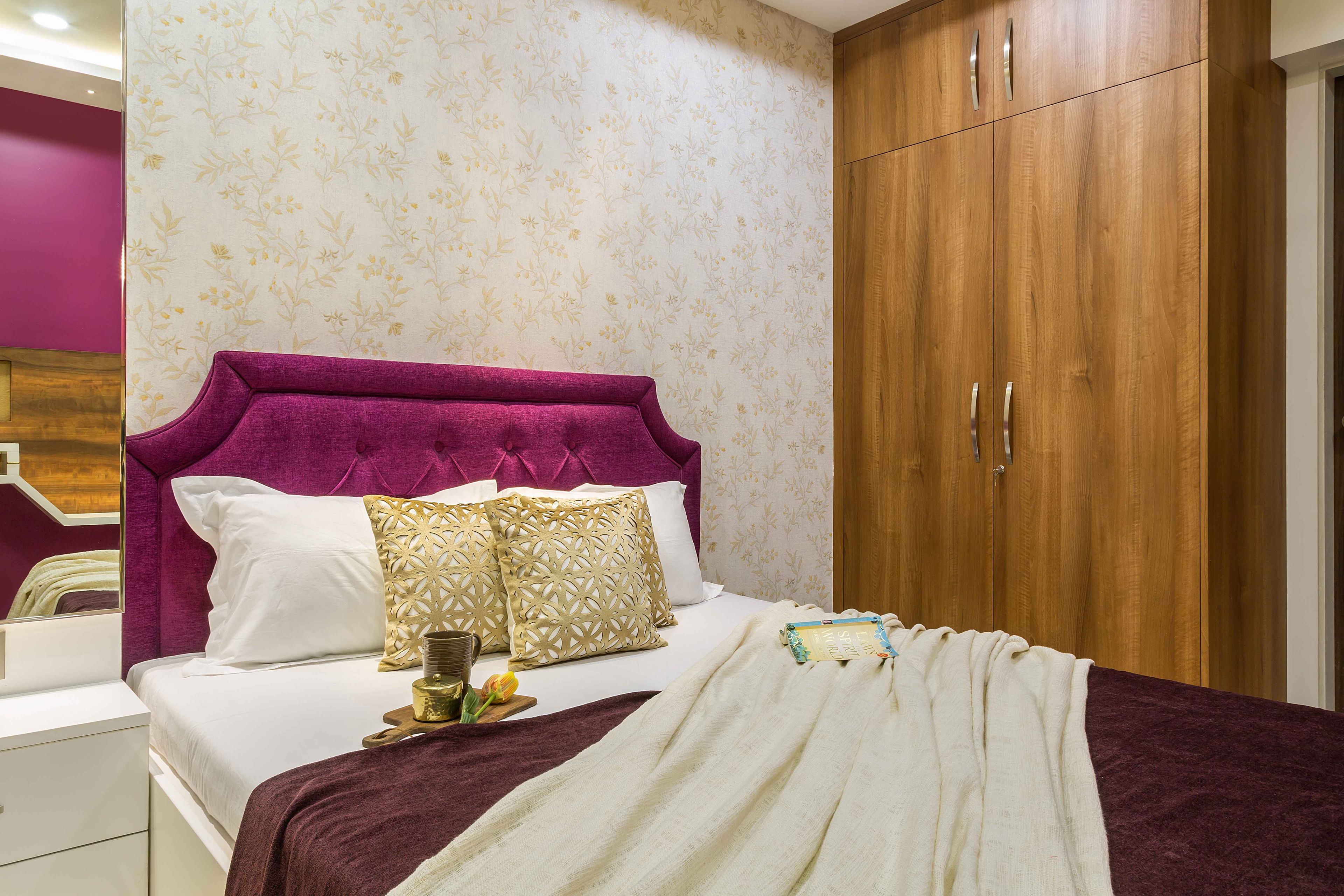 Guest room design with wooden wardrobe and purple headboard - Livspace