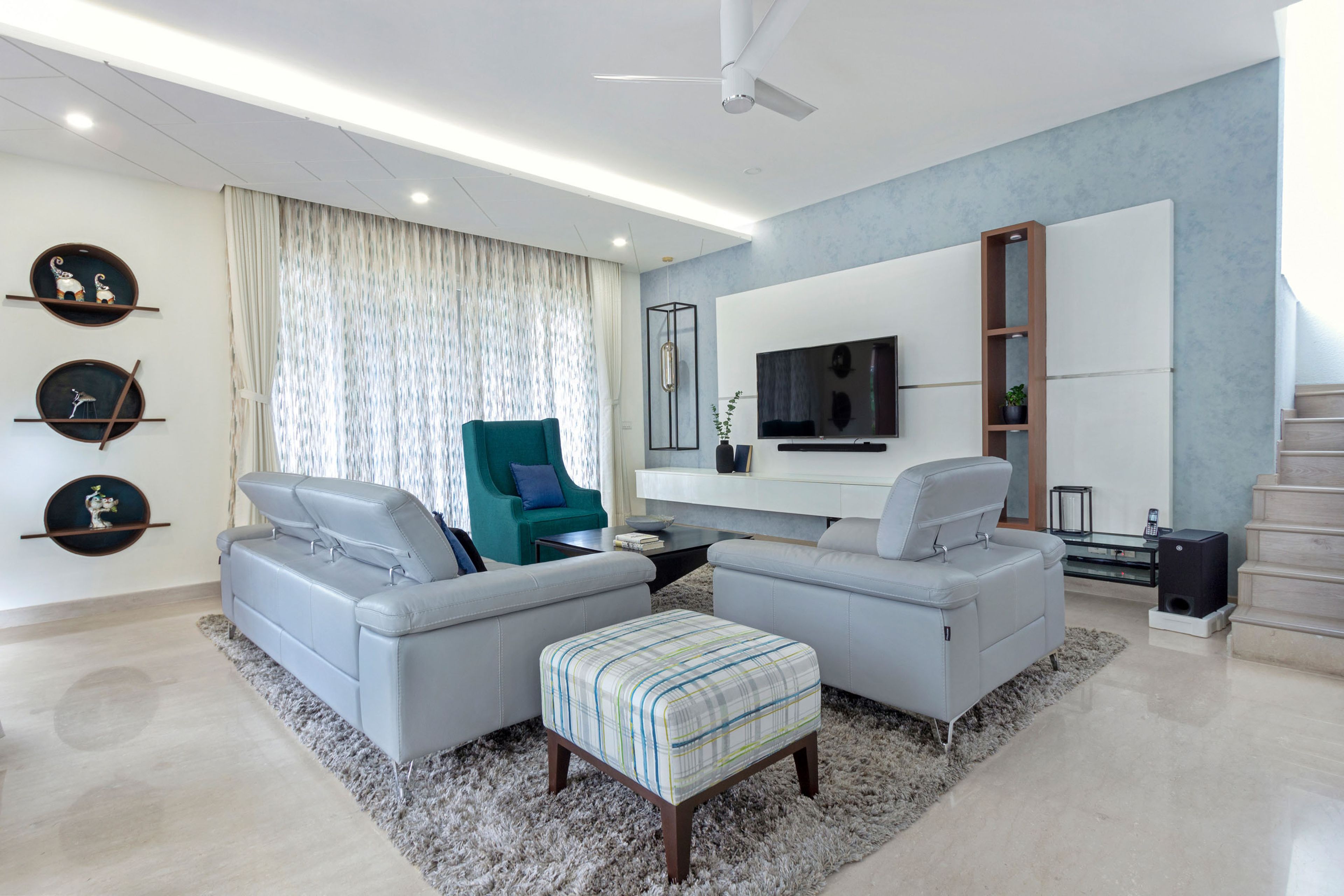 Grey and blue living room design with blue accent chair- Livspace