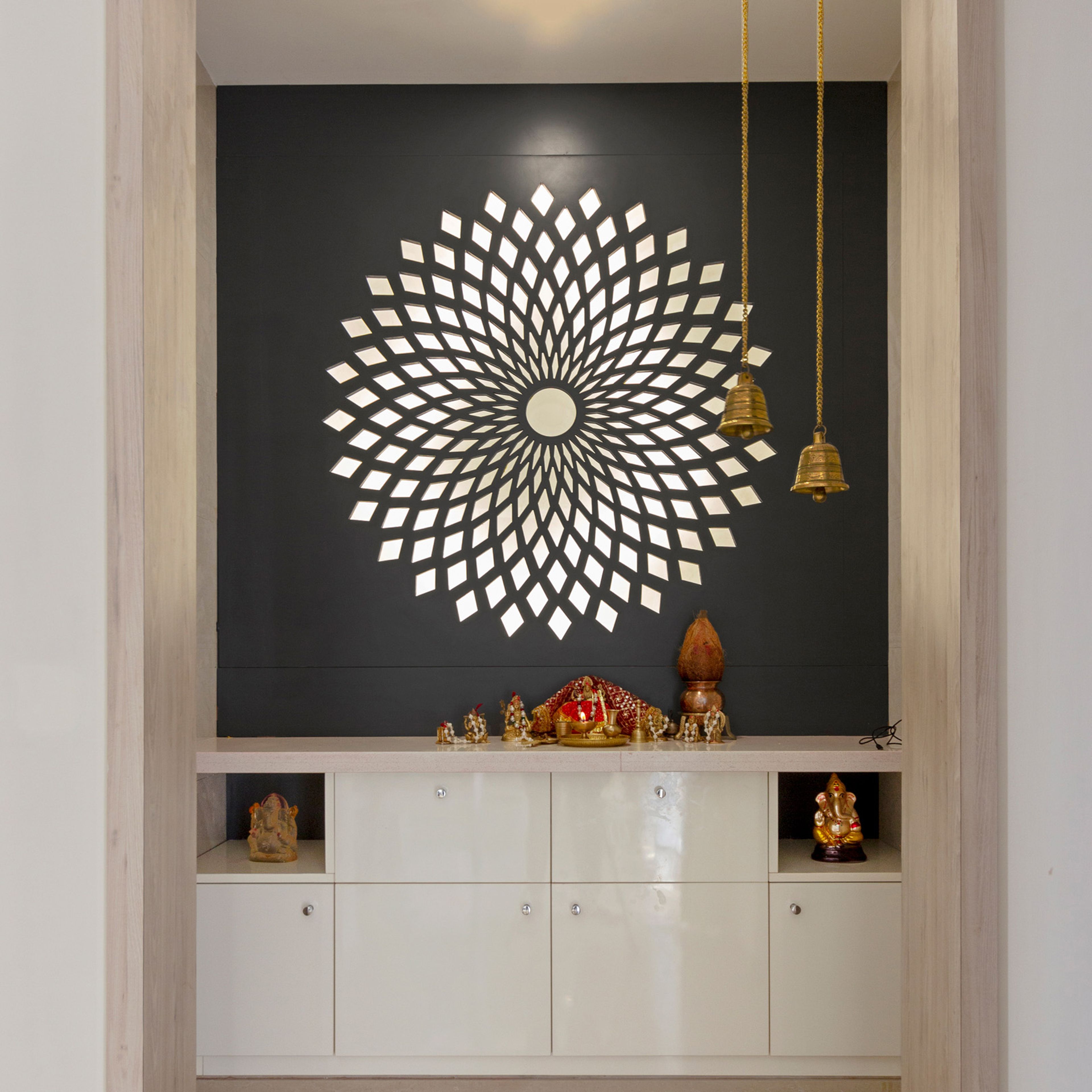 White pooja room design with black backdrop and mandala - Livspace