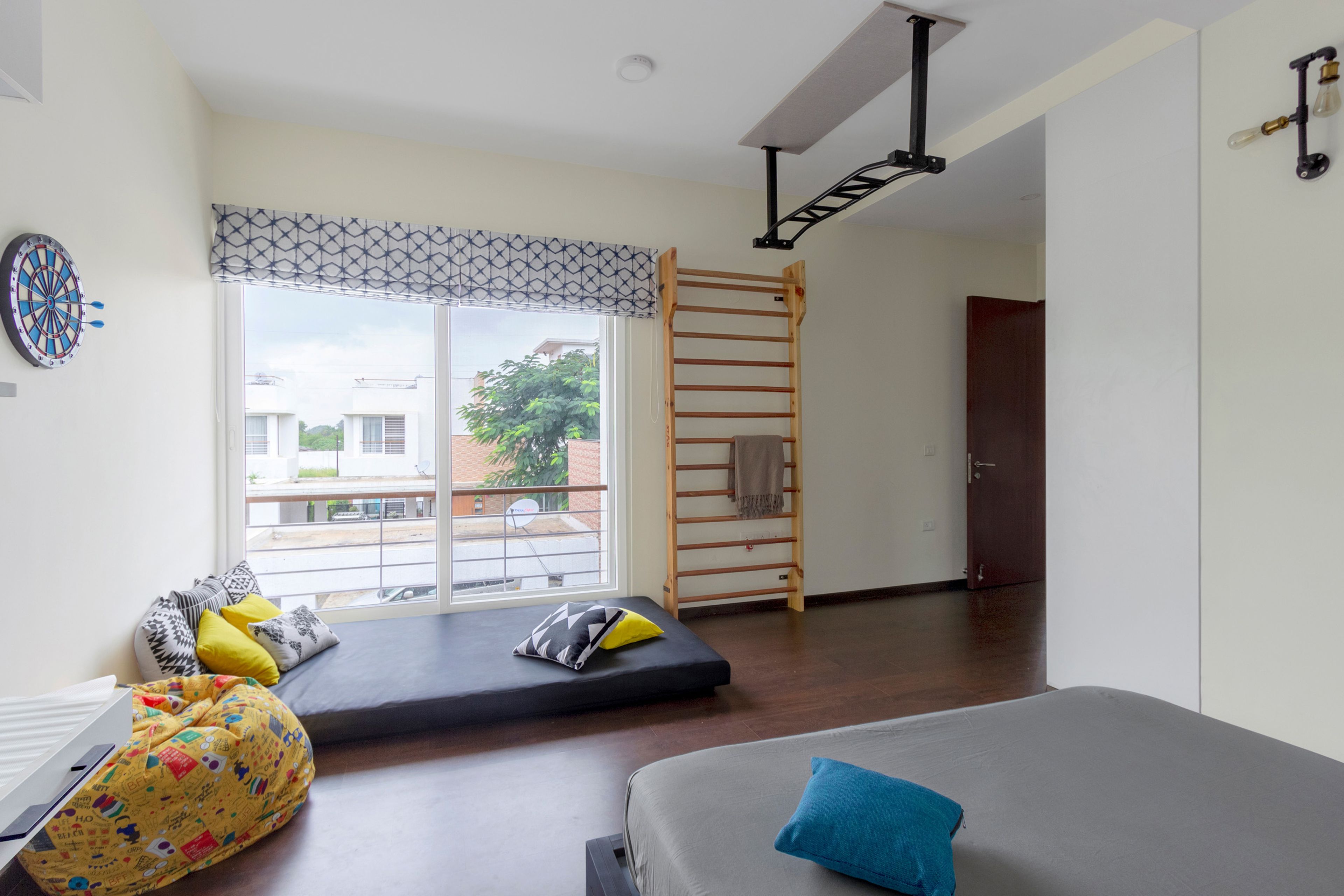 Dark grey floor mattress and yellow bean bag for the kids room - Livspace