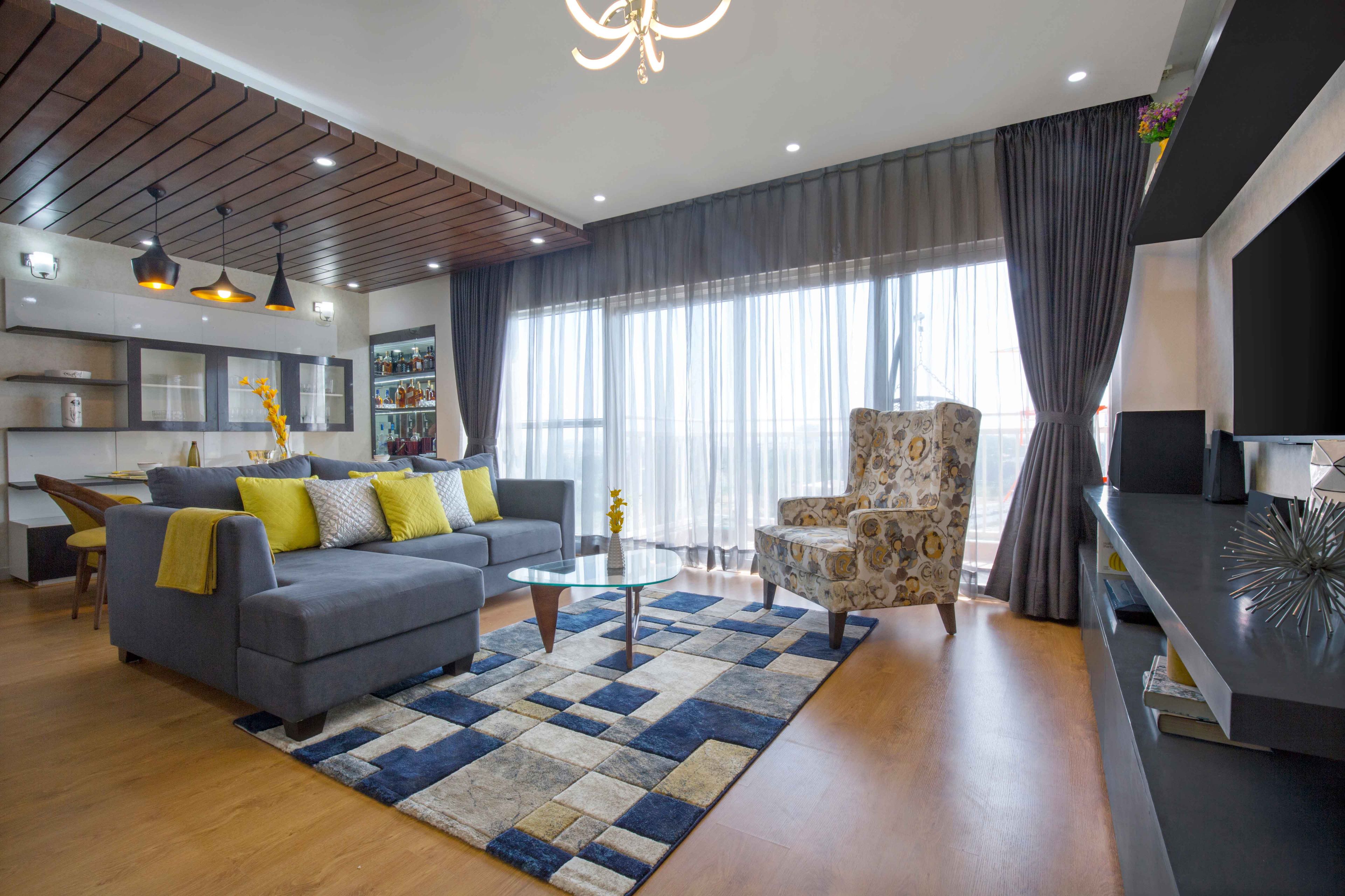 Grey and yellow spacious living room design with TV Unit - Livspace