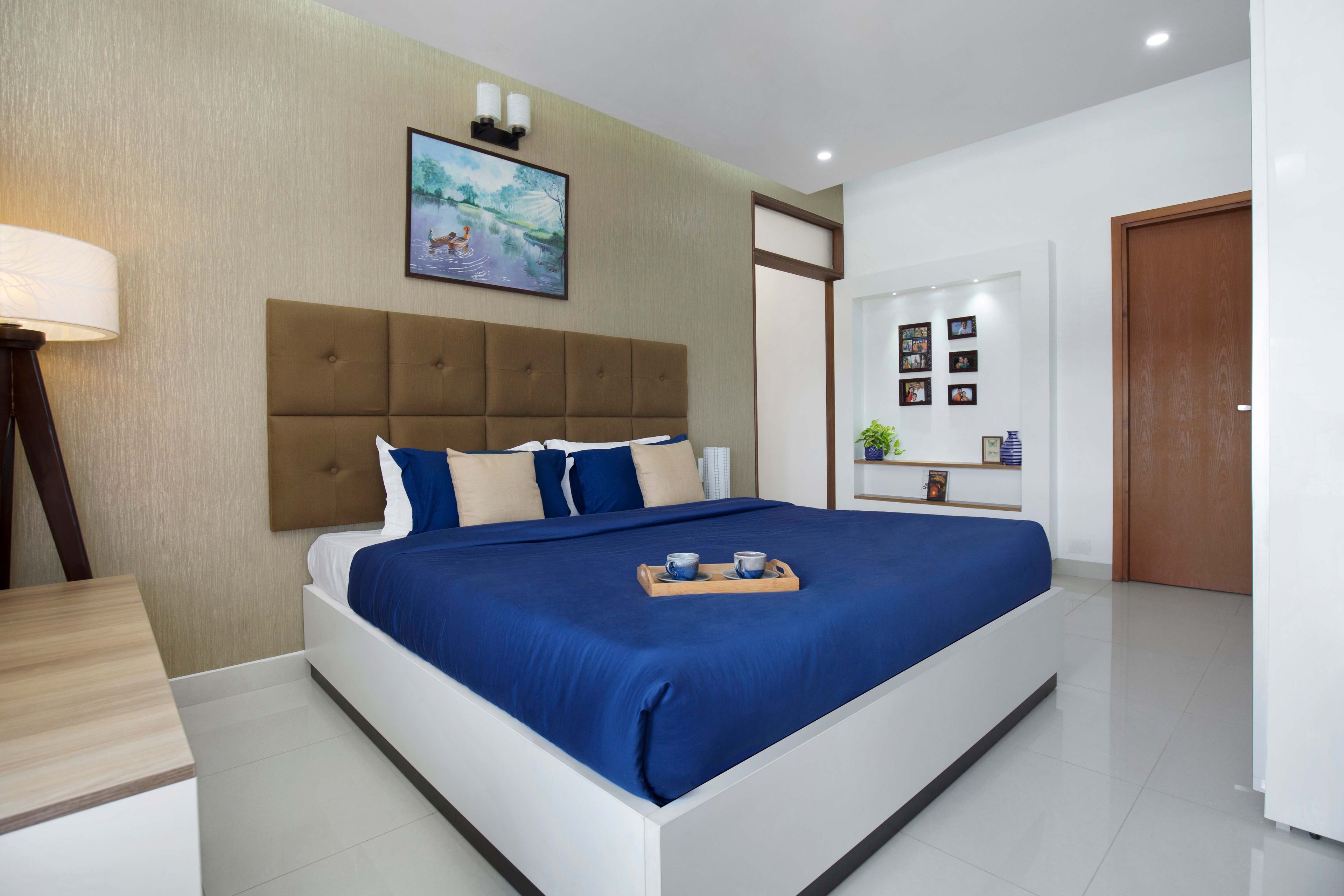 Blue and white upholstered bed with brown headboard - Livspace