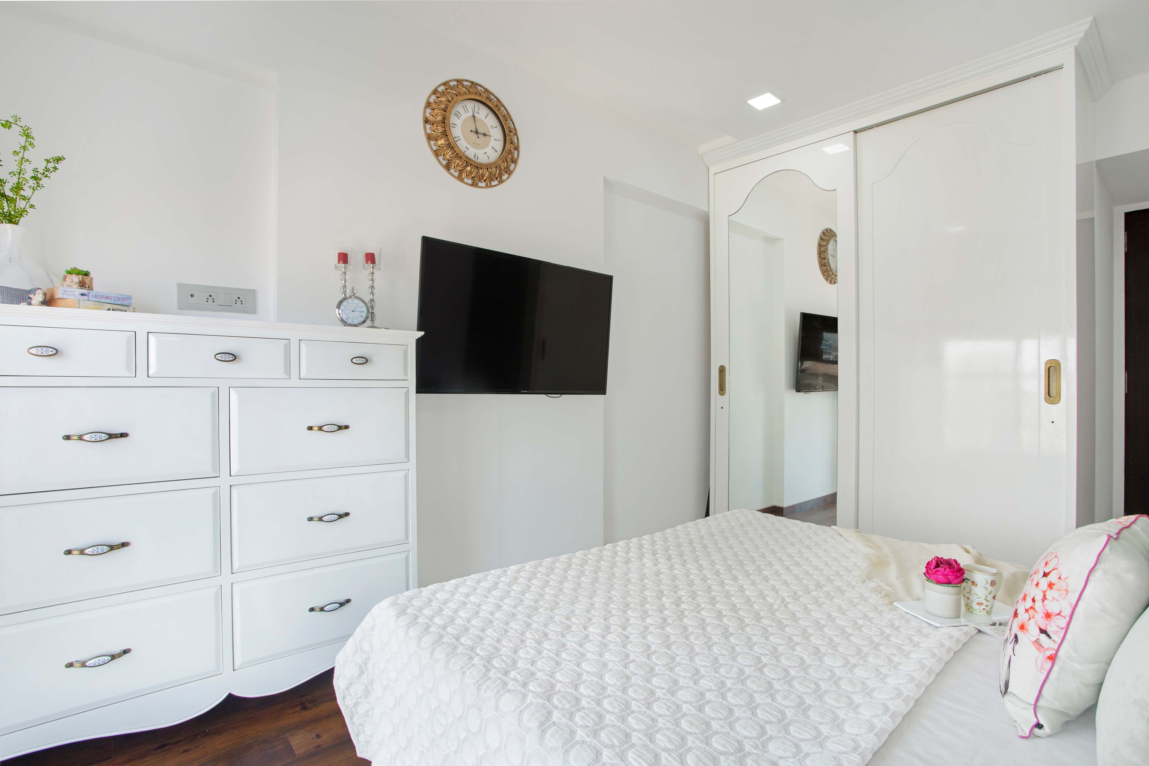 White drawer stroage cabinet and white mirrored sliding wardrobe for master bedroom - Livspace