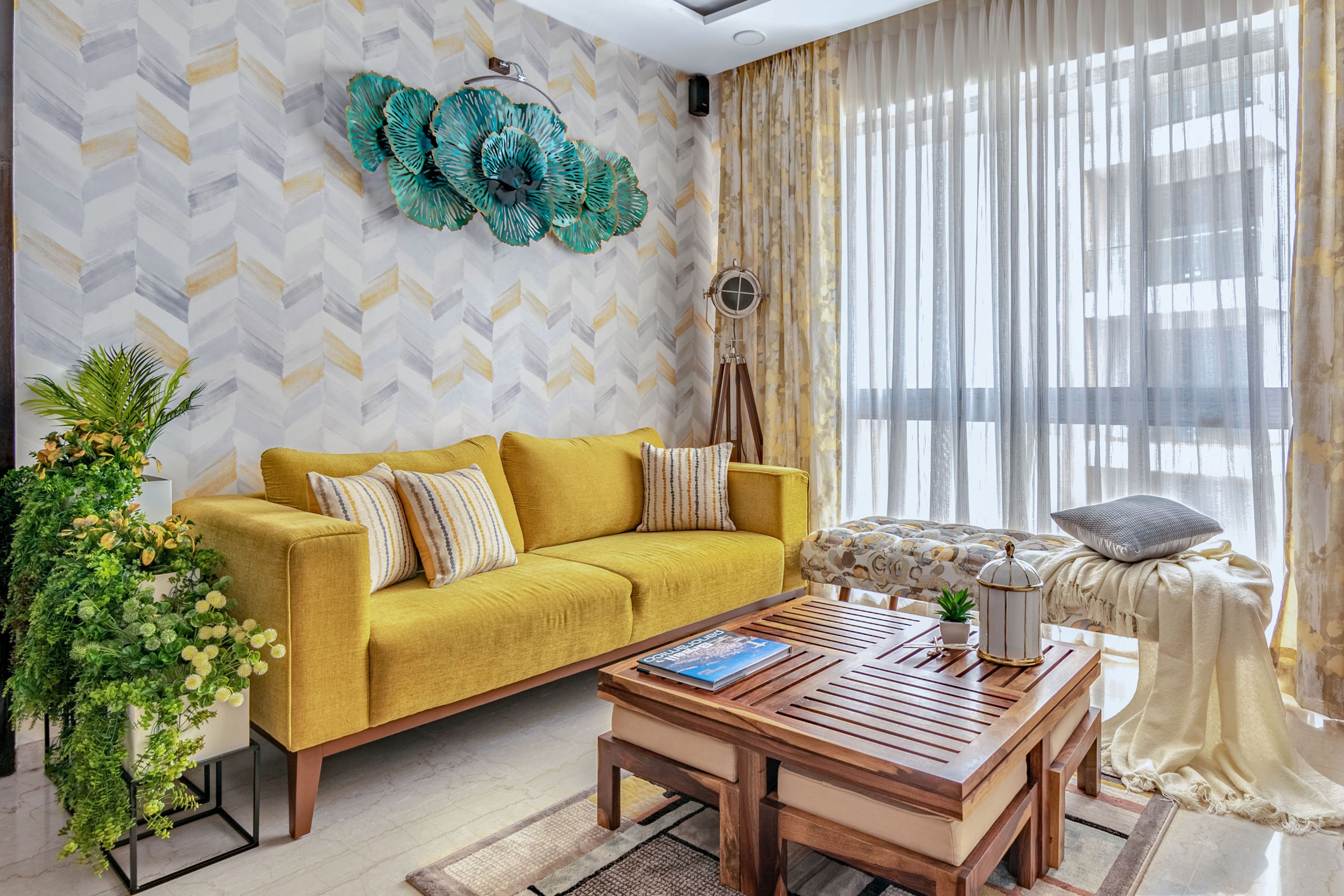 Multicoloured living room design with yellow sofa, herringbone wallpaper and abstract seater - Livspace