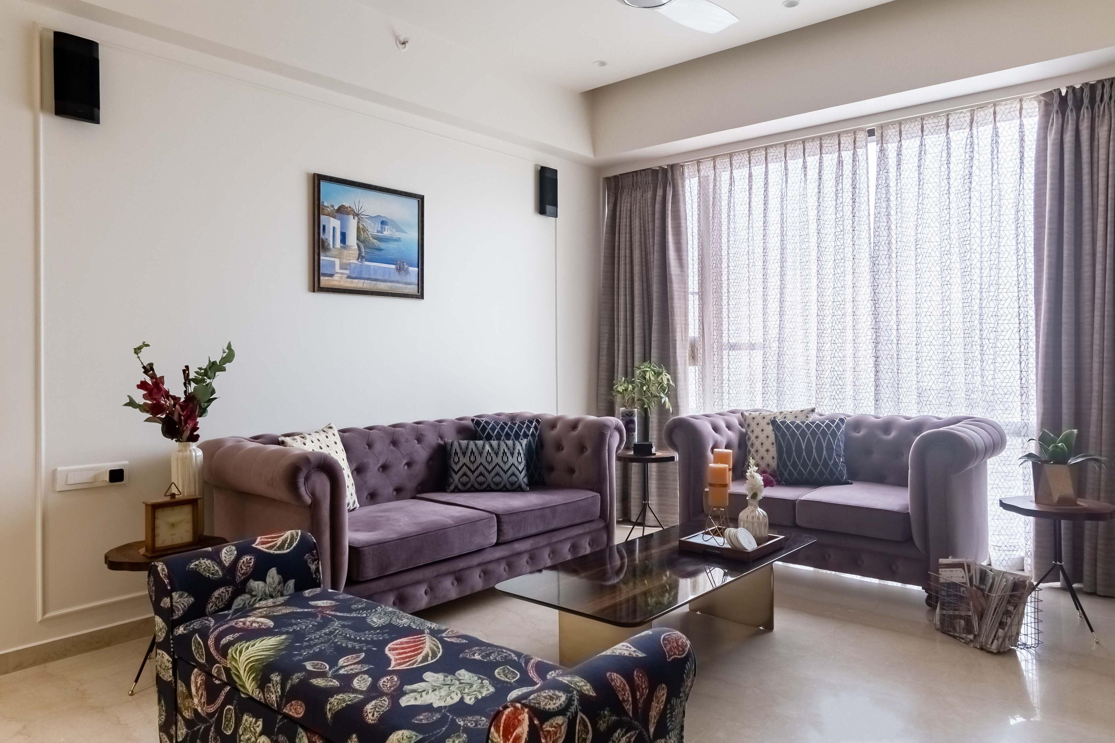 U-shaped living room design with purple and blue accent sofas - Livspace