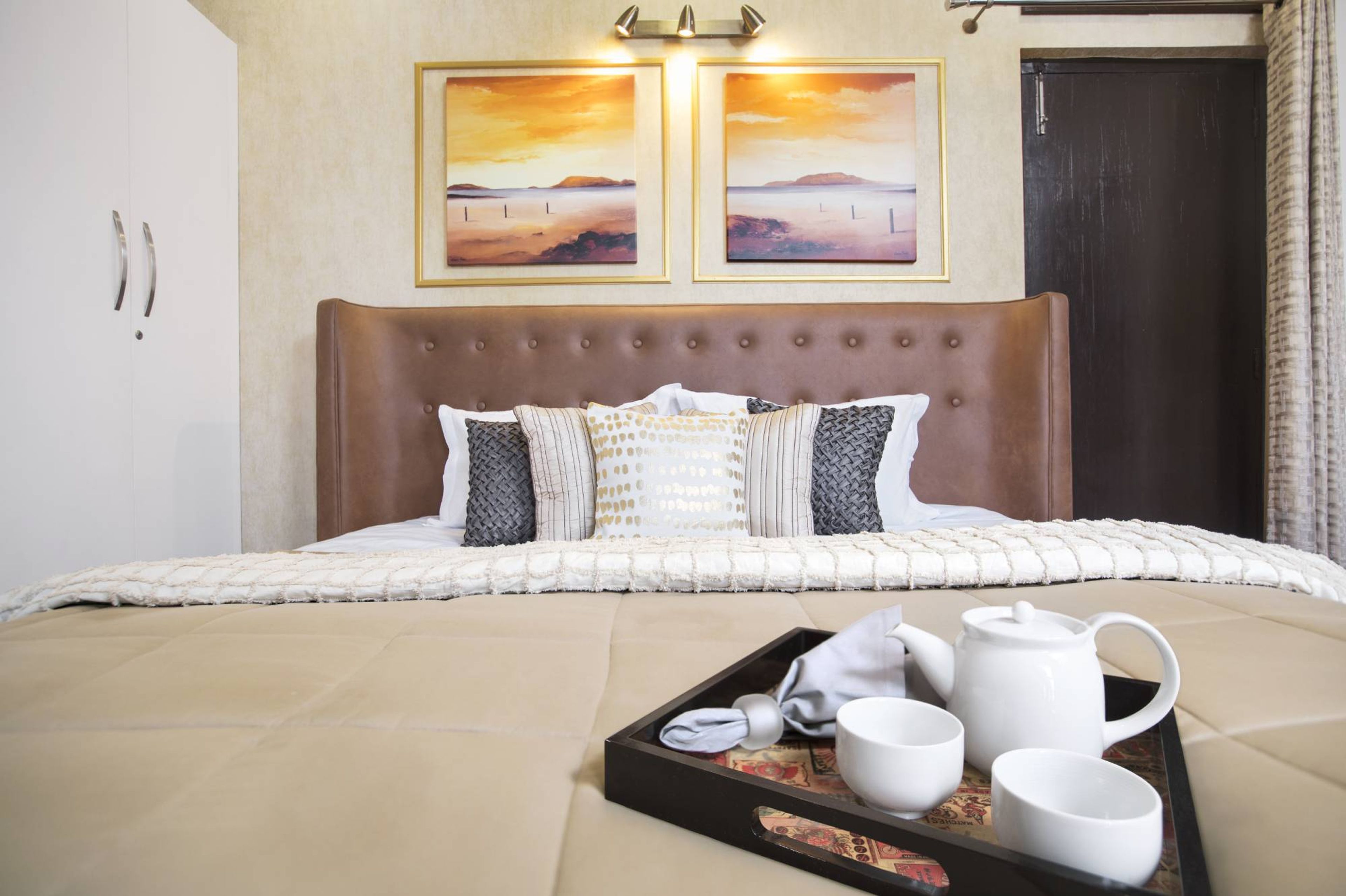 Modern Guest Room Design With Brown Tufted Headboard And White Wardrobe