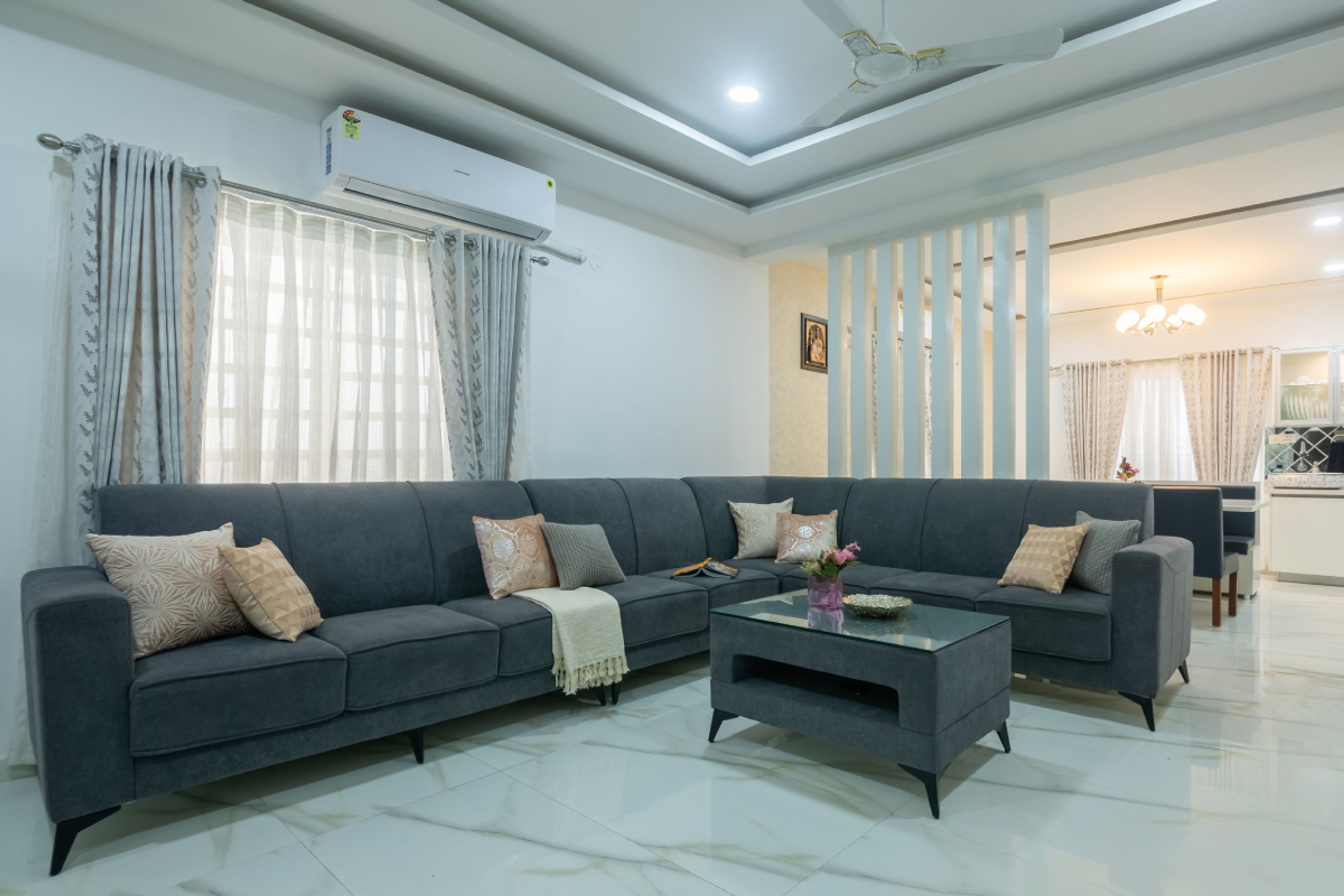 Living Room With L-Shaped Grey Sofa And White Louvers - Livspace