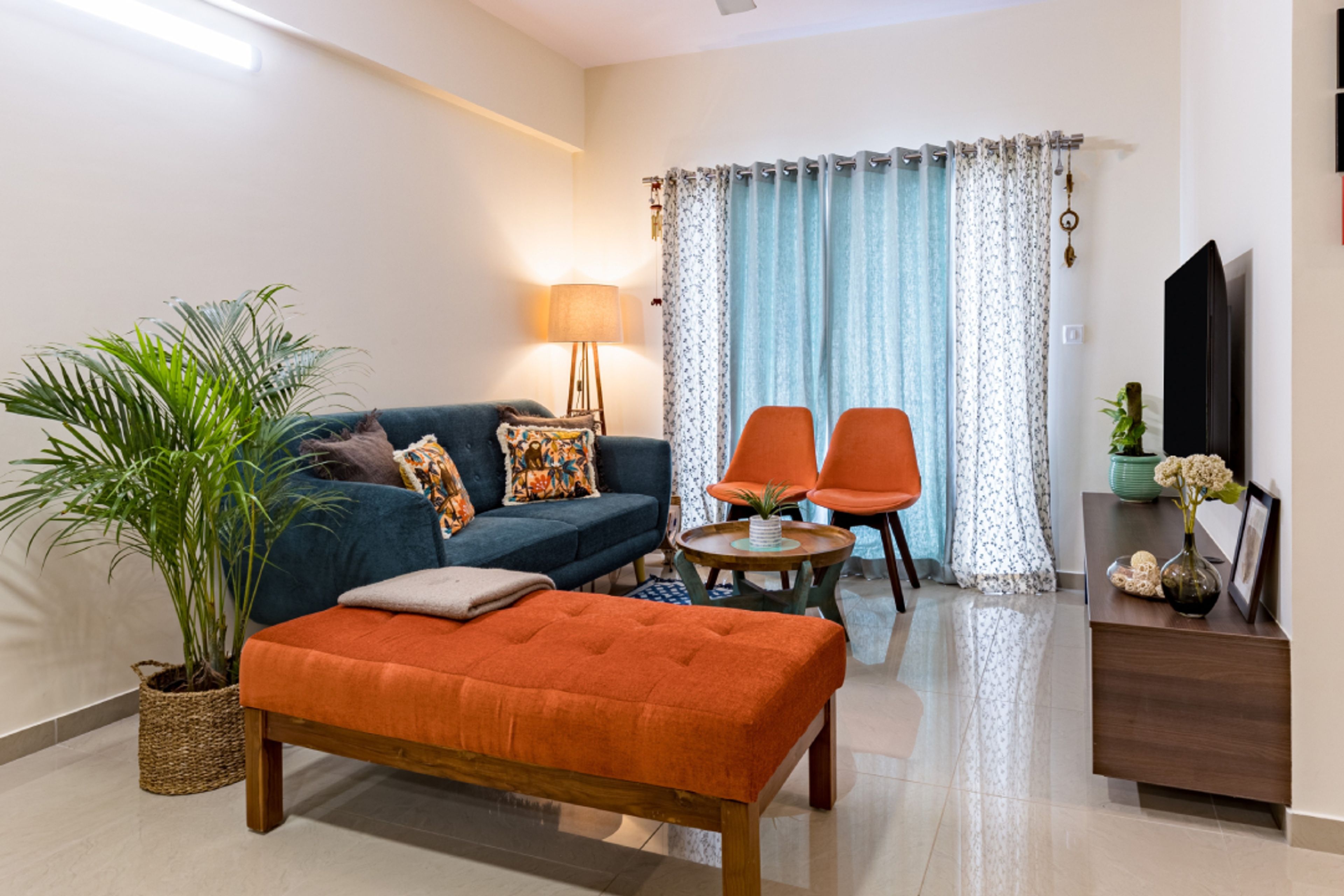 Modern Living Room Design With A 2-Seater Blue Sofa And 2 Orange Chairs