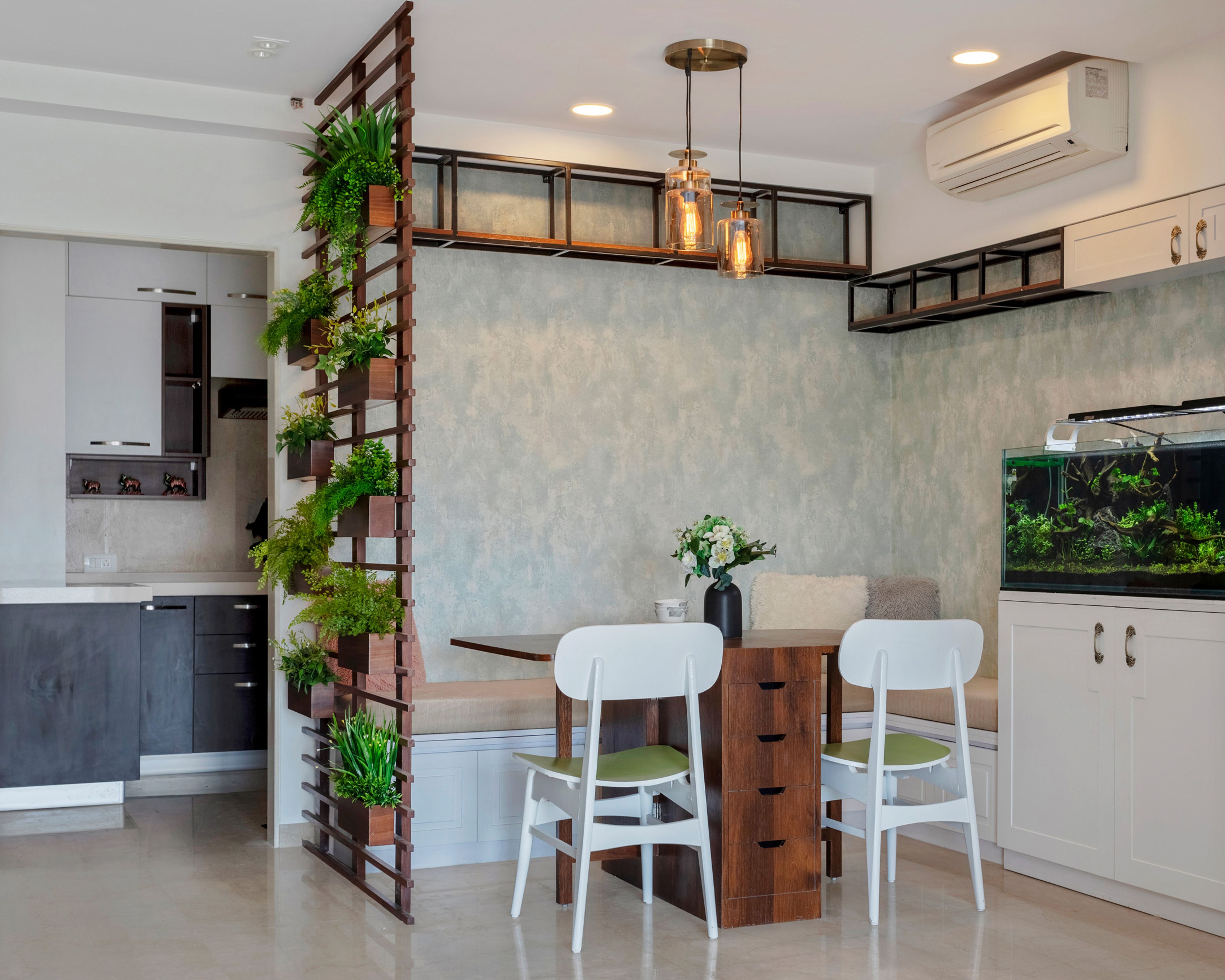 Open Dining Room Plan With Open Wooden Partition, Green Potted Plants, L-Shaped Seating And Aquarium - Livspace