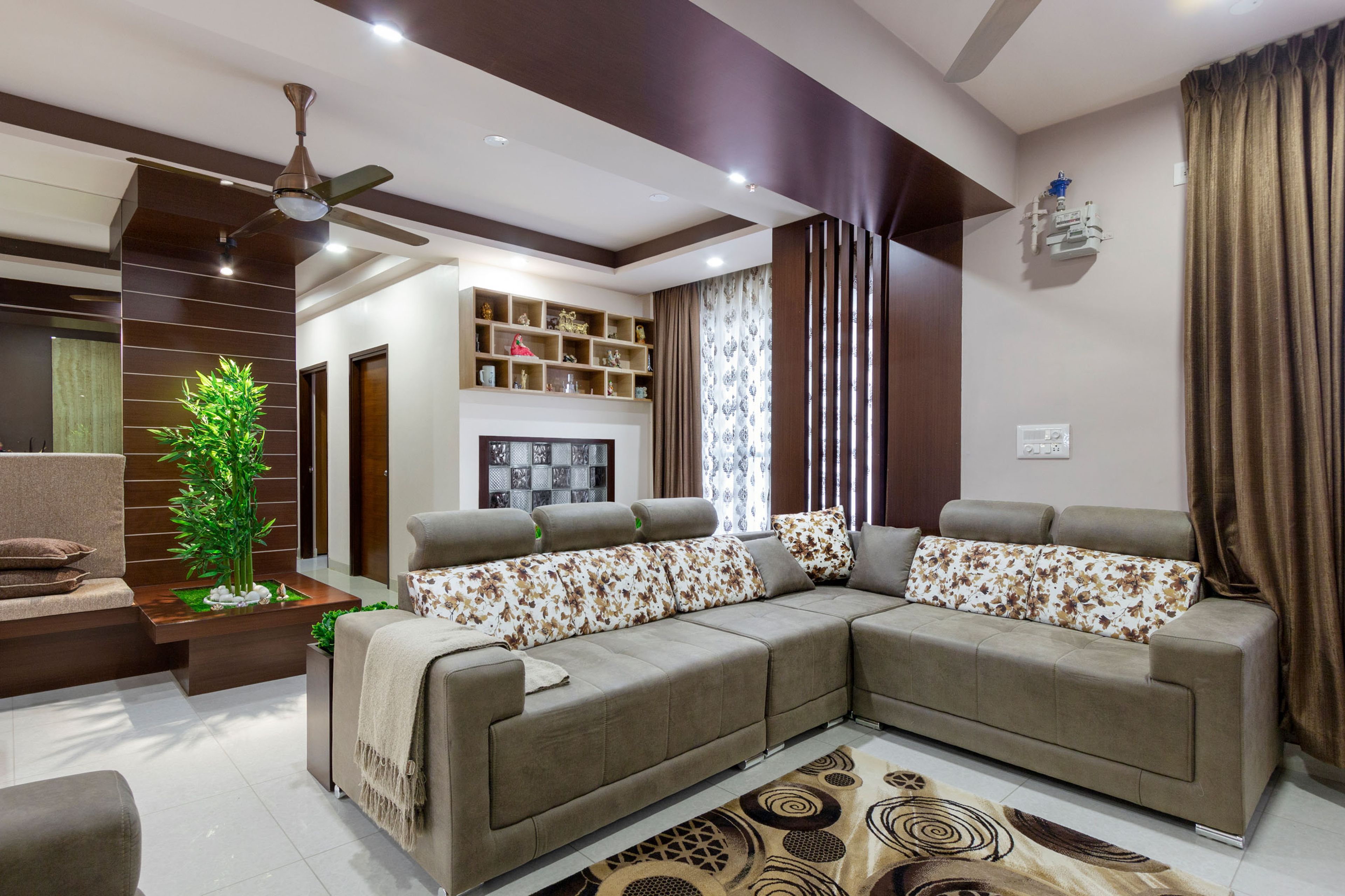 Living Room Design With Spacious L-Shaped Beige Sofa And Patterned Cushions - Livspace