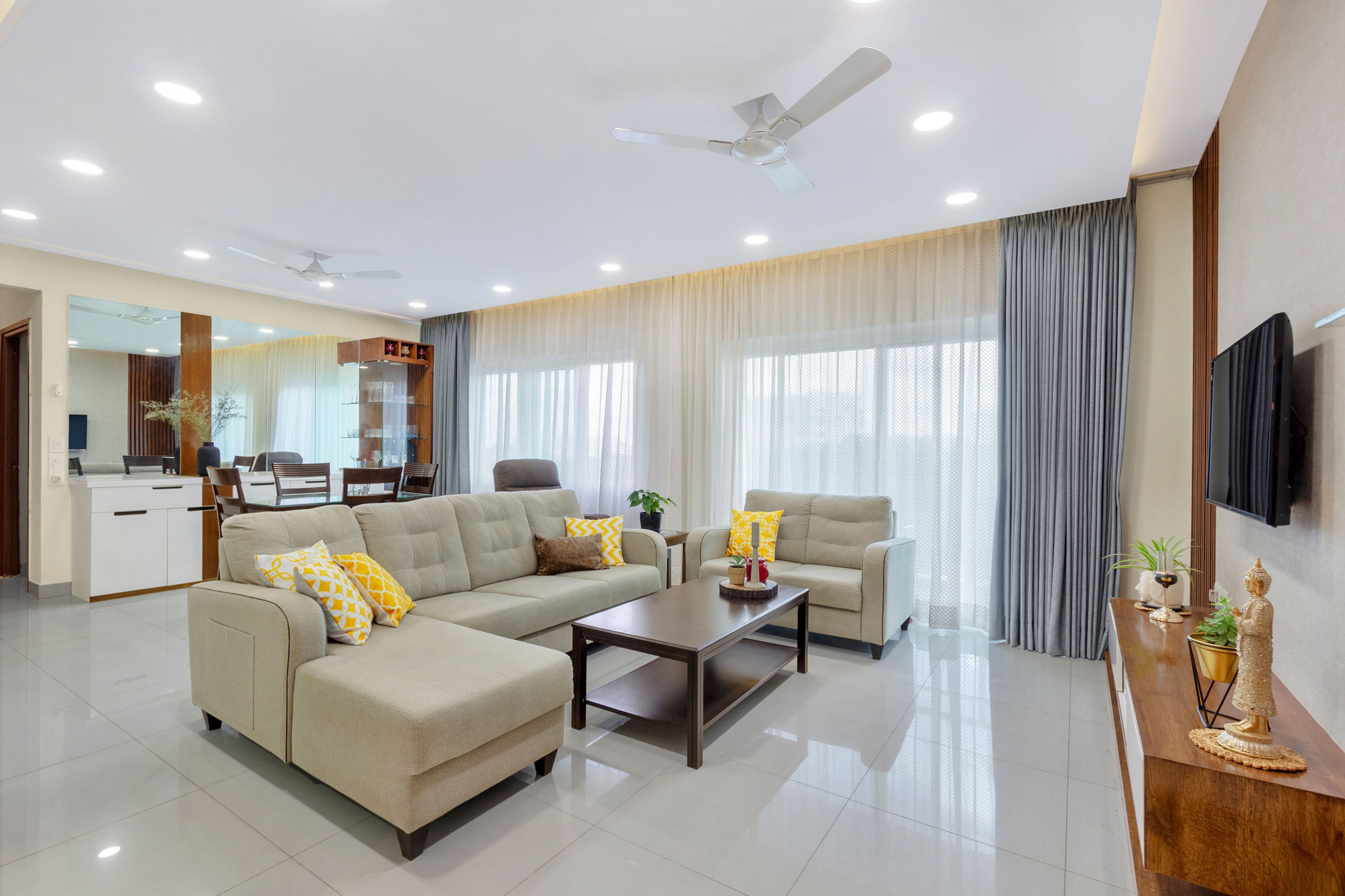 Spacious Beige Living Room Design With Sectional And TV Unit - Livspace