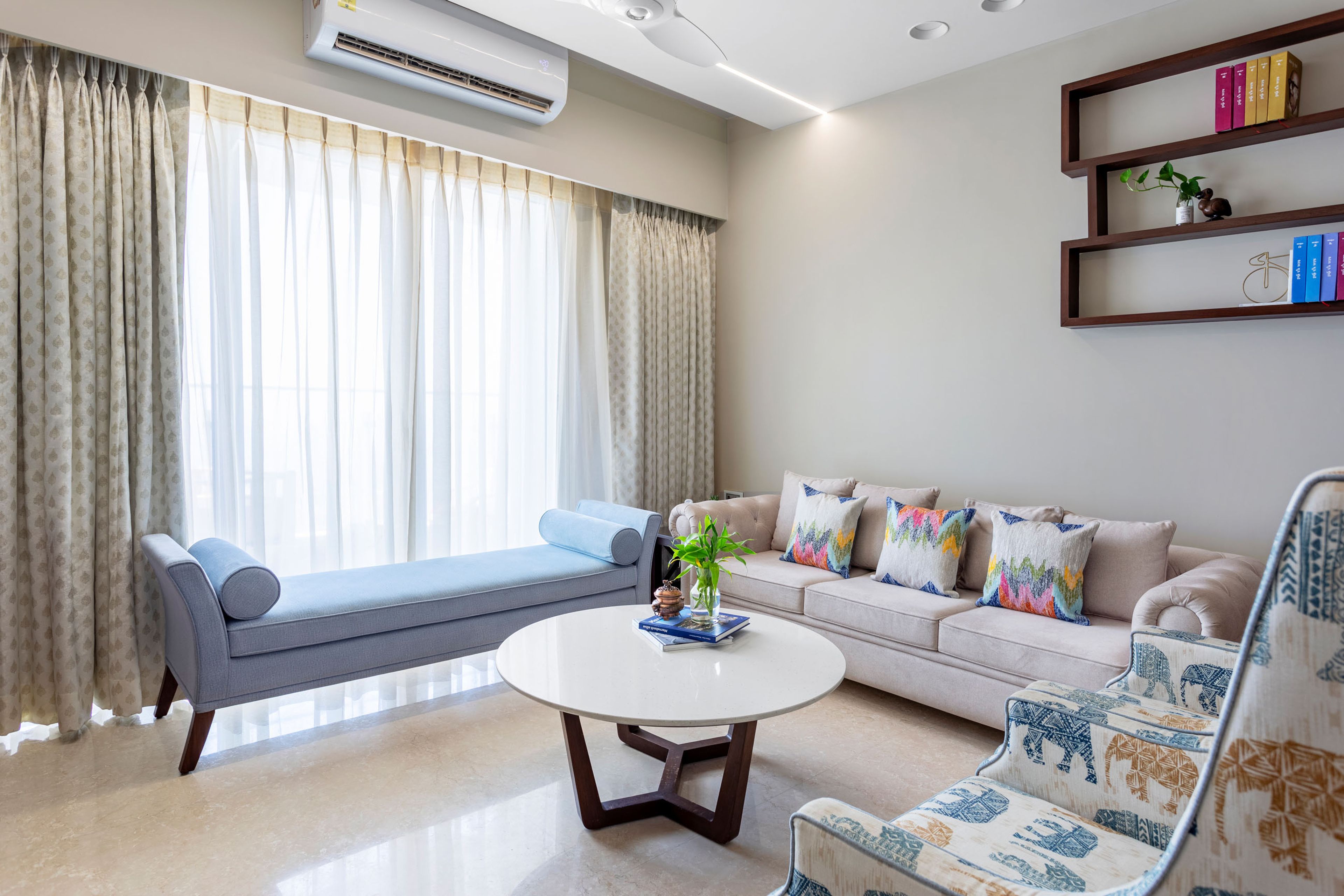 Spacious Living Room With Beige Sofa, Patterned Accent Chairs And Blue Seater - Livspace