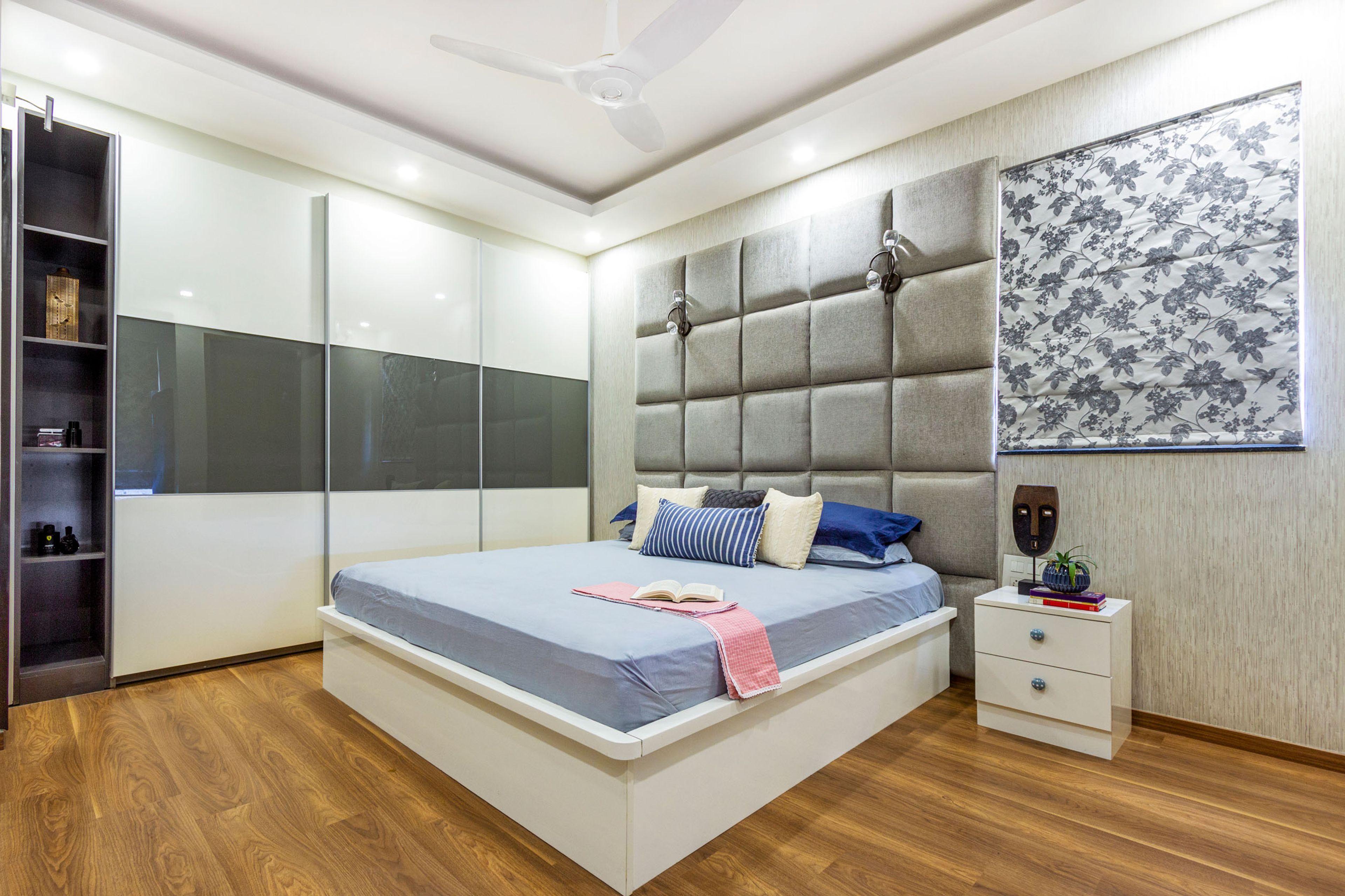 Master Bedroom With Chequered Grey Headboard And 3-Door Sliding Wardrobe In White And Grey - Livspace