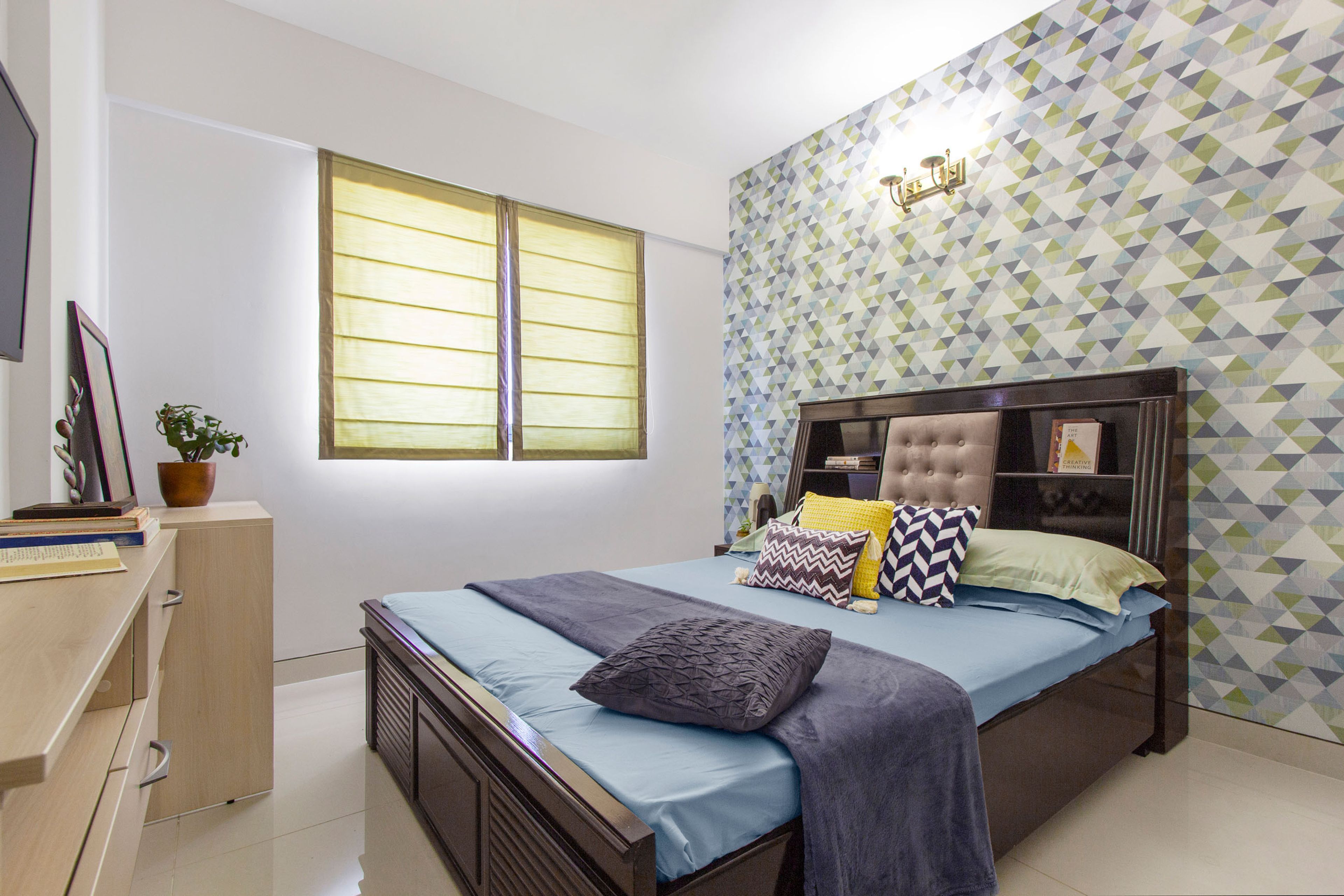 Guest Room With Wooden Bed And Multicoloured Geometric Wallpaper Design - Livspace