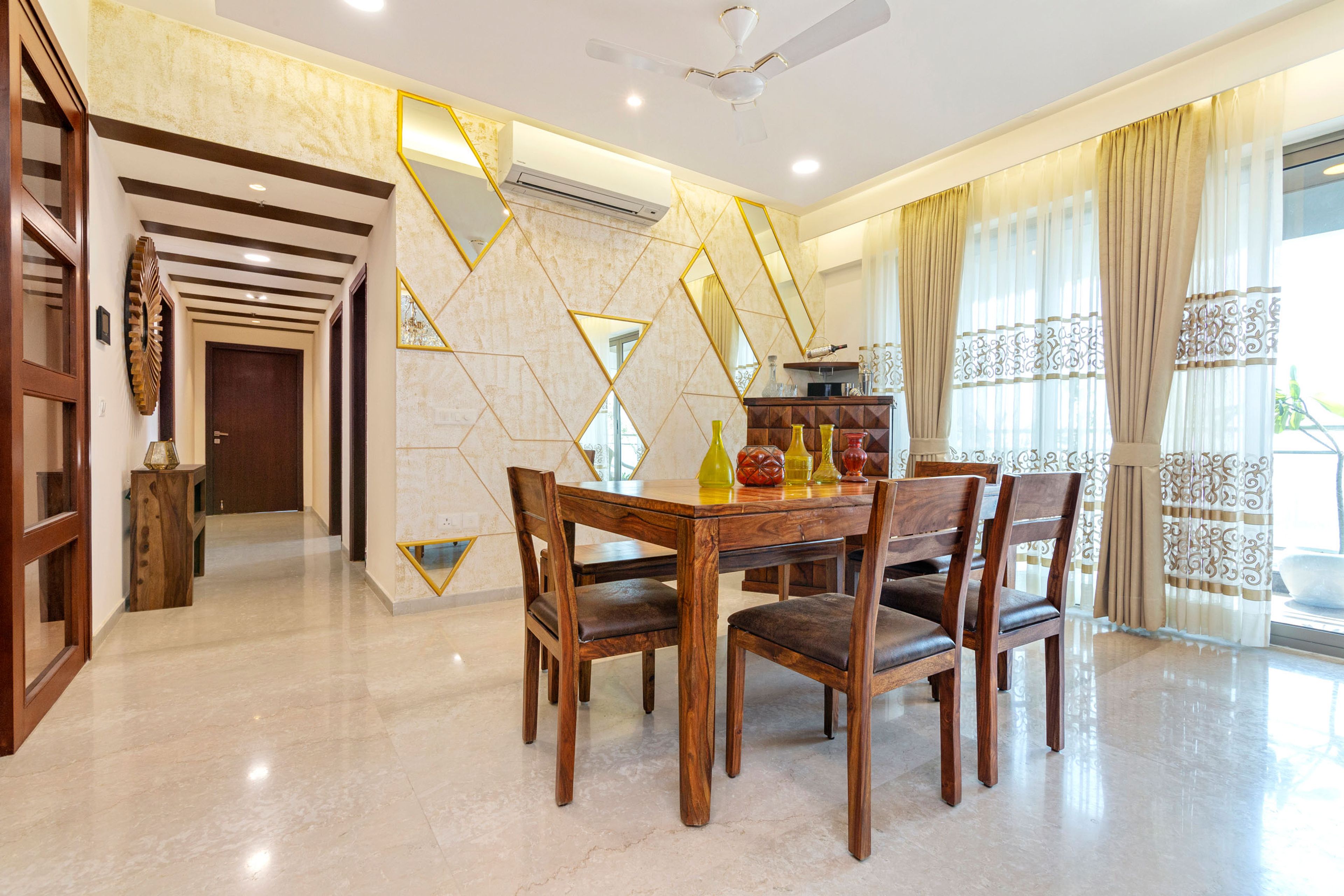 Dining Room Design With 4-Seater Wooden Dining Table, Long Bench, Wooden 3D Bar Unit And Beige Accent Wall With Mirrors - Livspace