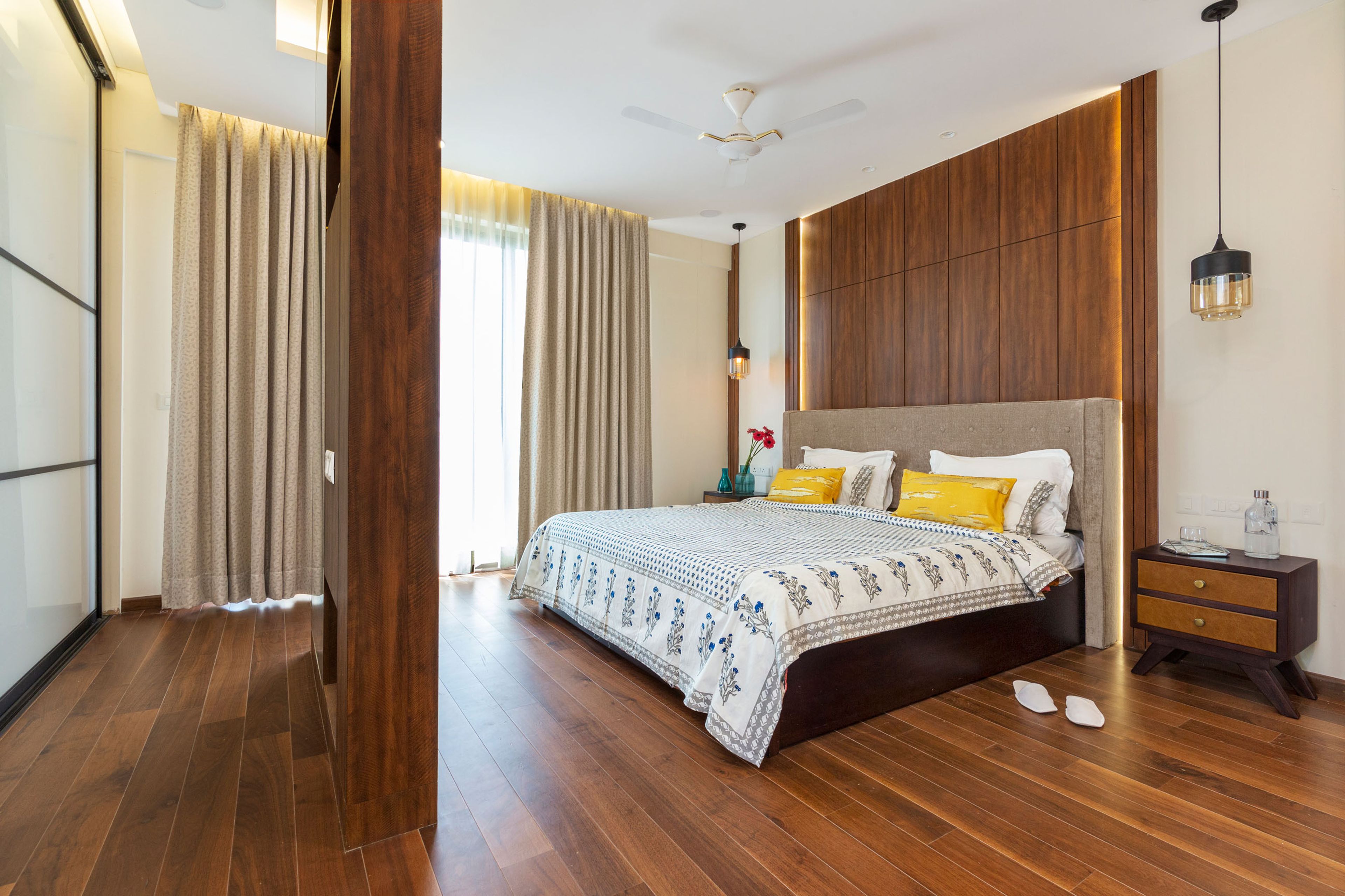 Master Bedroom With Wooden Accent Wall, Wooden TV Partition Wall Unit And Wooden Flooring - Livspace