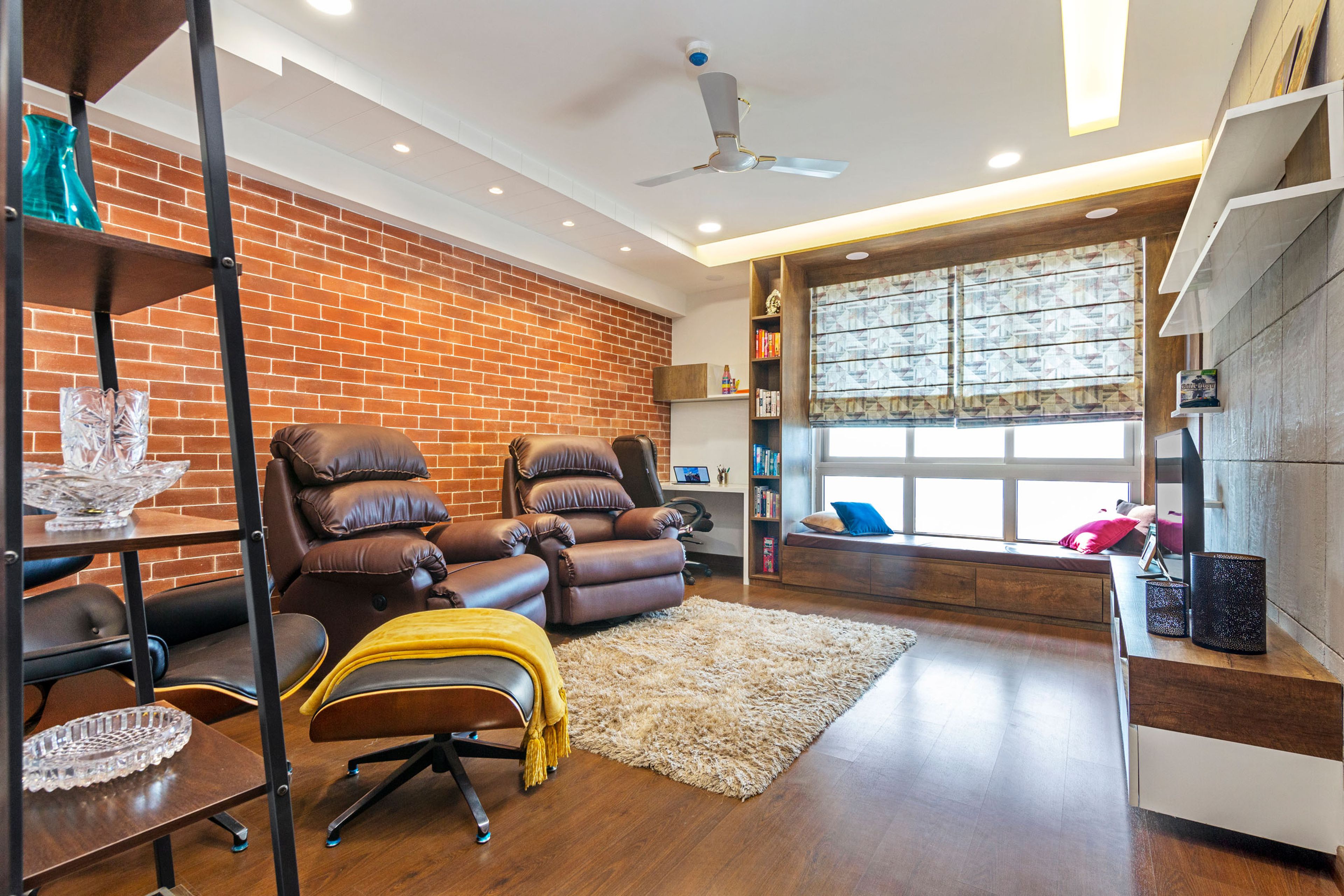 Family Room With Two Dark Brown Leather Recliner Chairs And Red Brick Accent Wall - Livspace