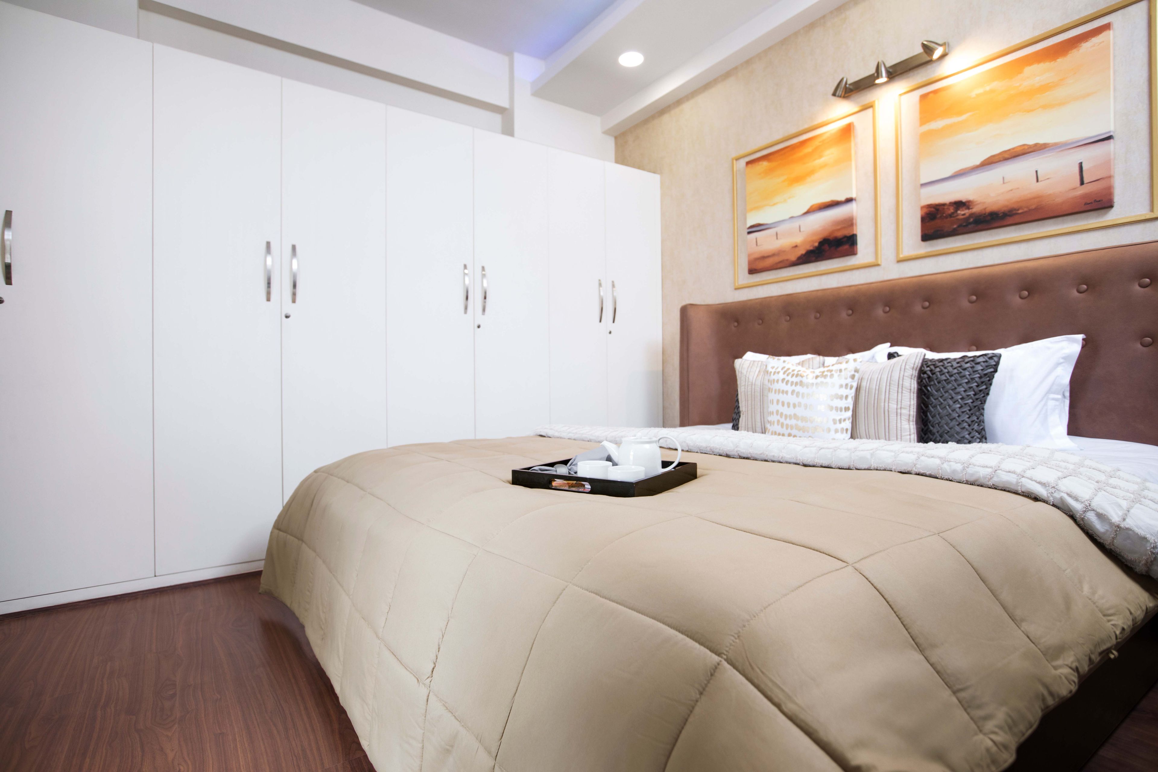 Master Bedroom With Brown Headboard And 9-Door Swing Wardrobe - Livspace