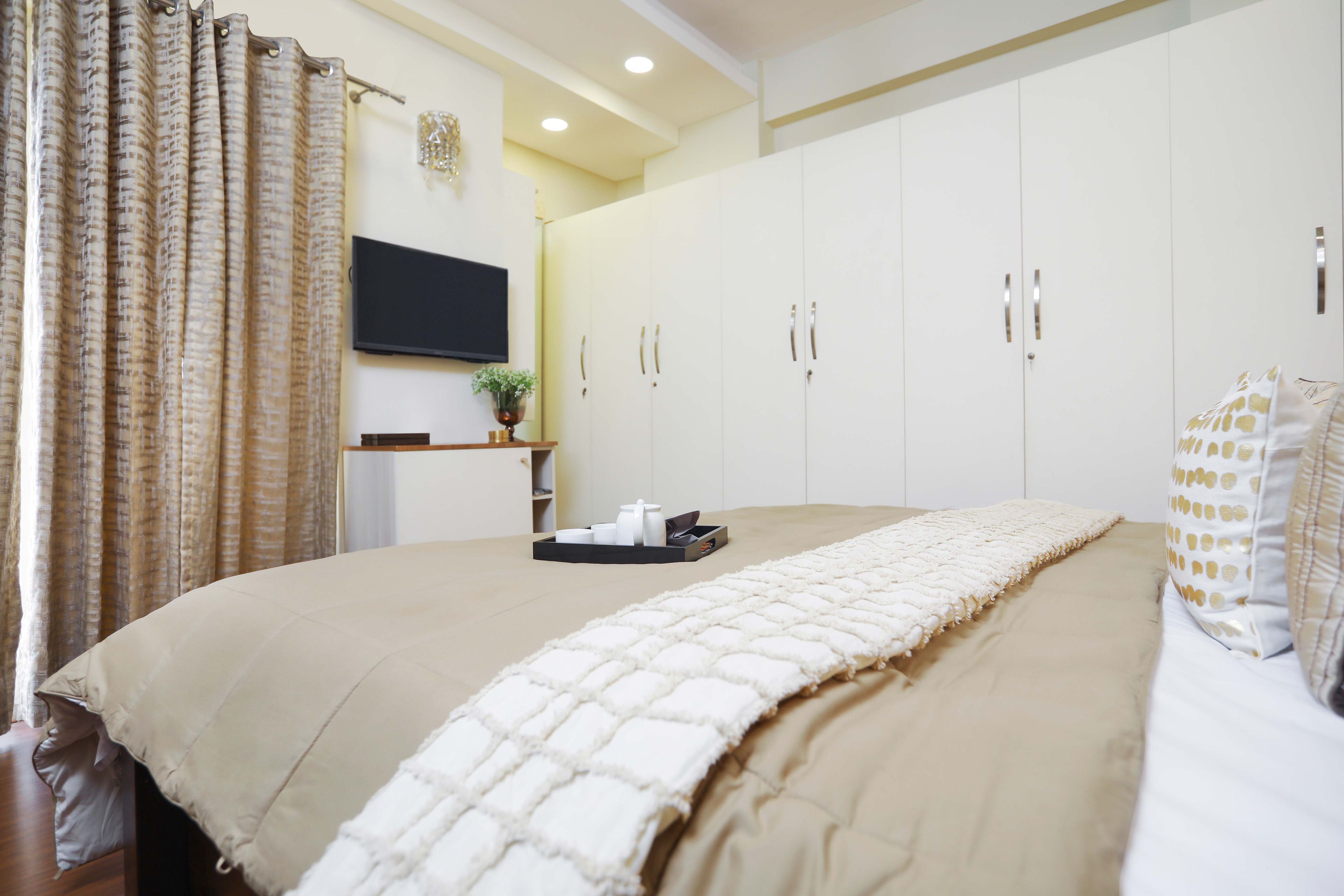 9-Door White Swing Wardrobe With White And Wood TV Unit For Master Bedroom - Livspace