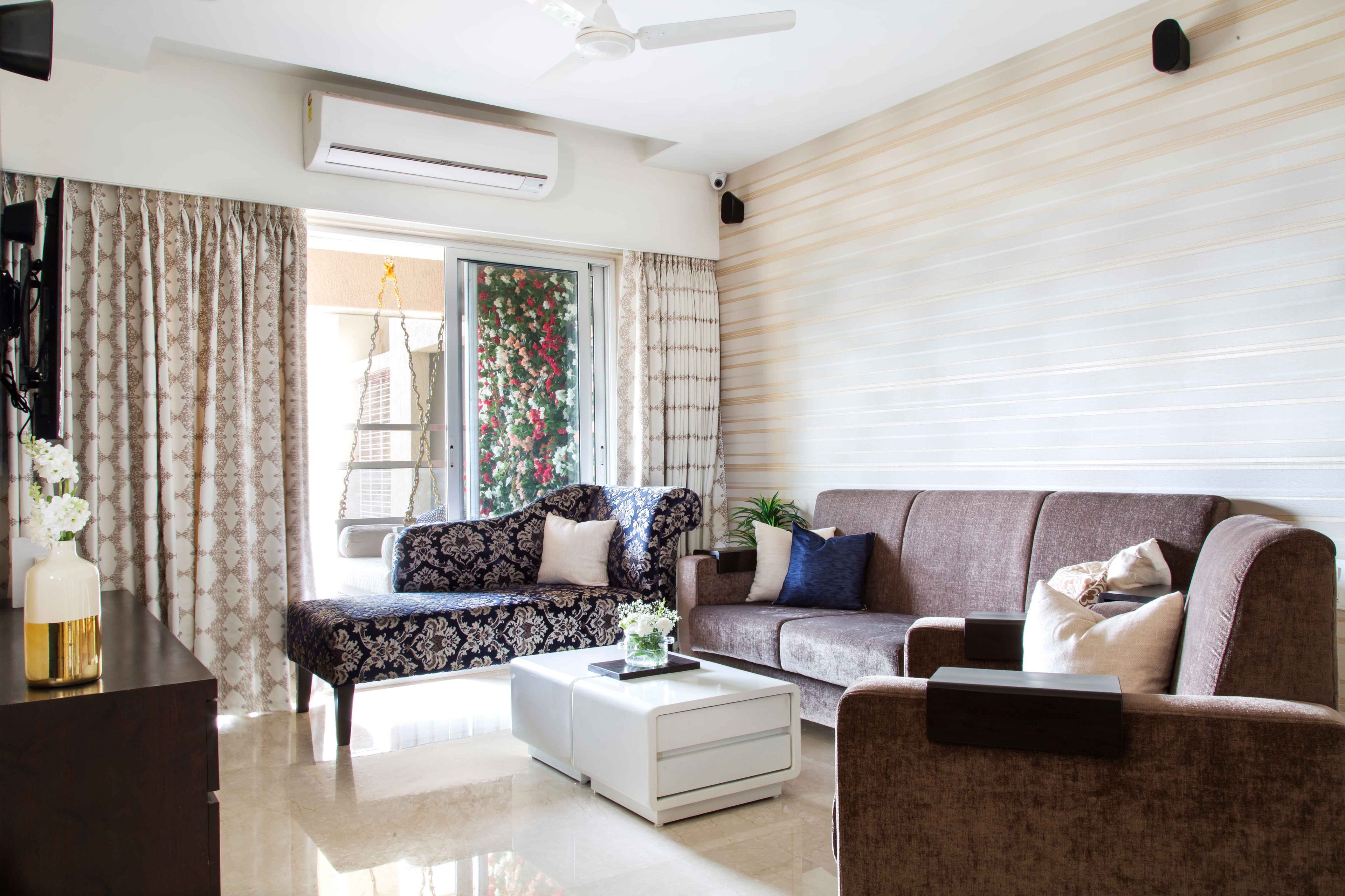 Spacious Living Room With Brown Sofa, Striped White And Gold Accent Wall And Patterned Accent Seater - Livspace