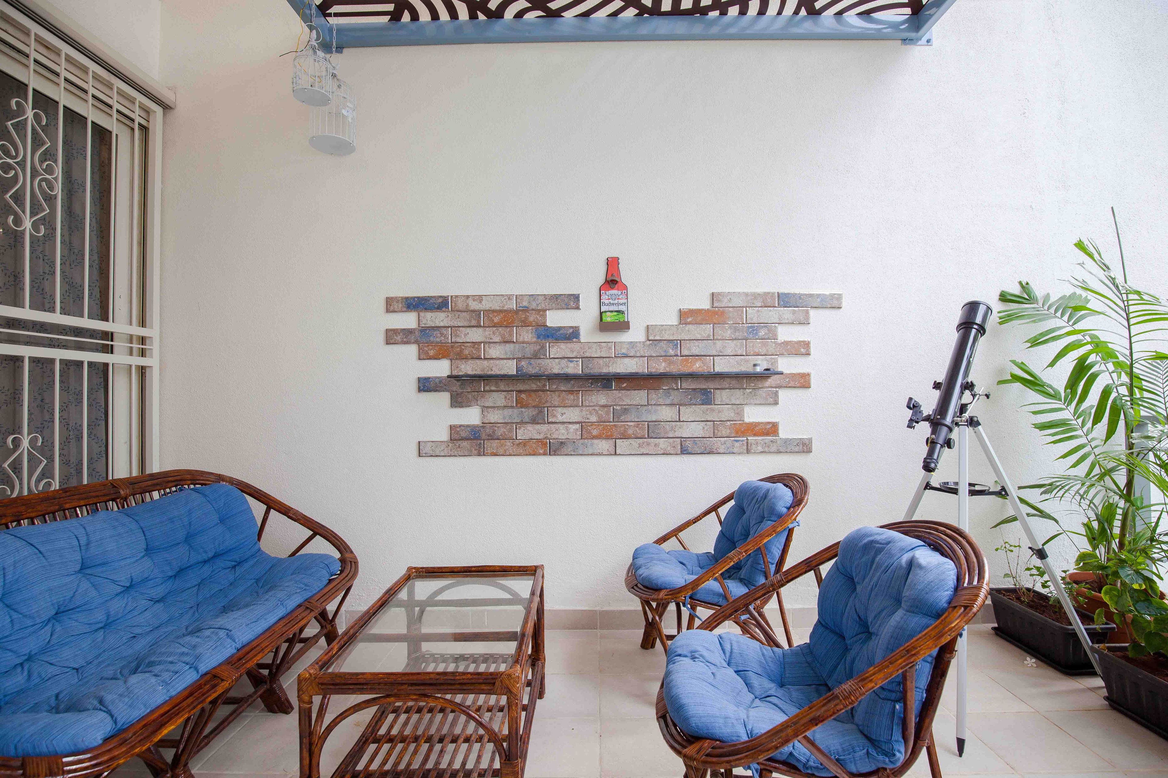 Spacious Balcony With Wood And Blue Furniture And Telescope - Livspace