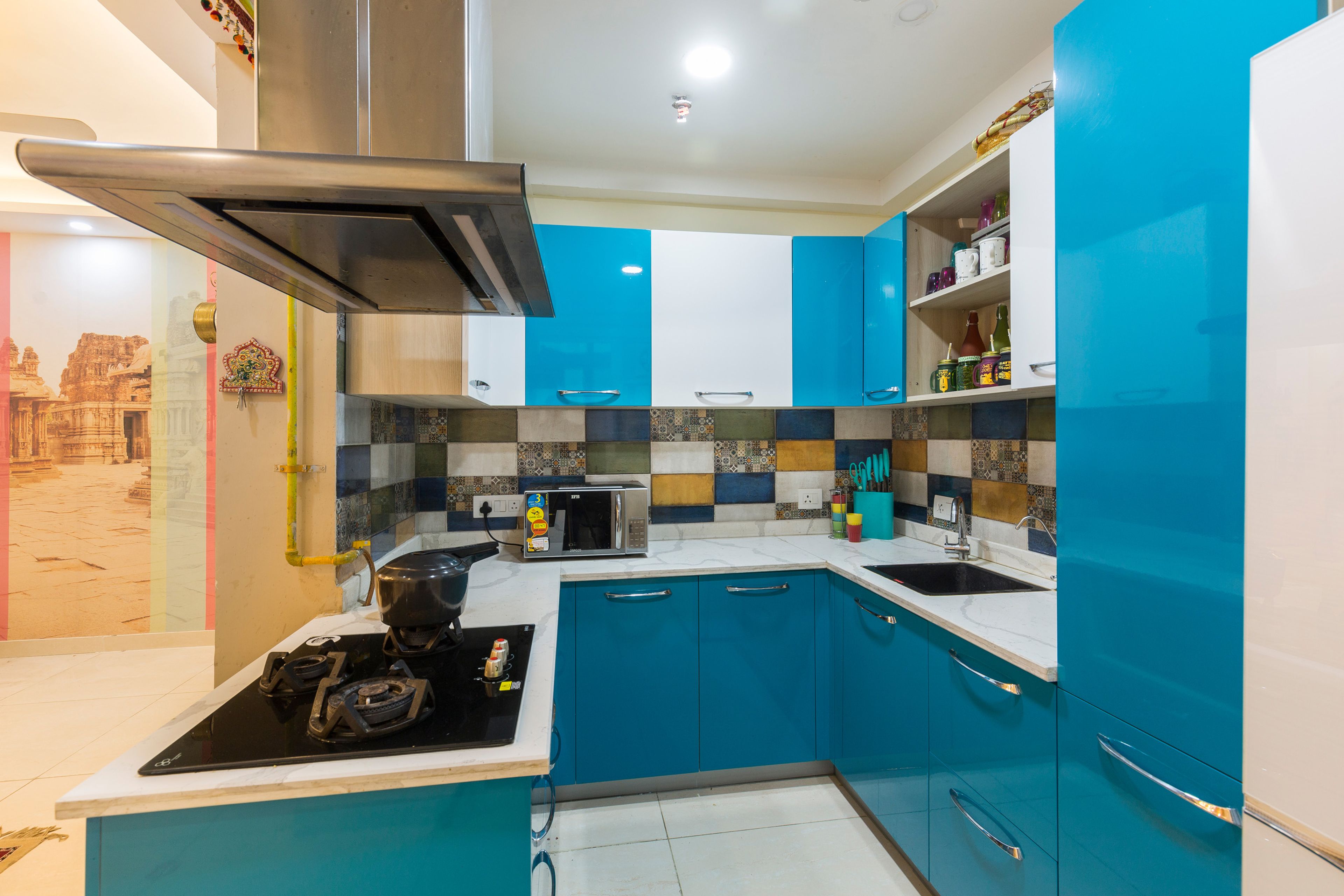 U-Shaped Glossy White And Blue Compact Kitchen With Multicoloured Dado Tiles - Livspace