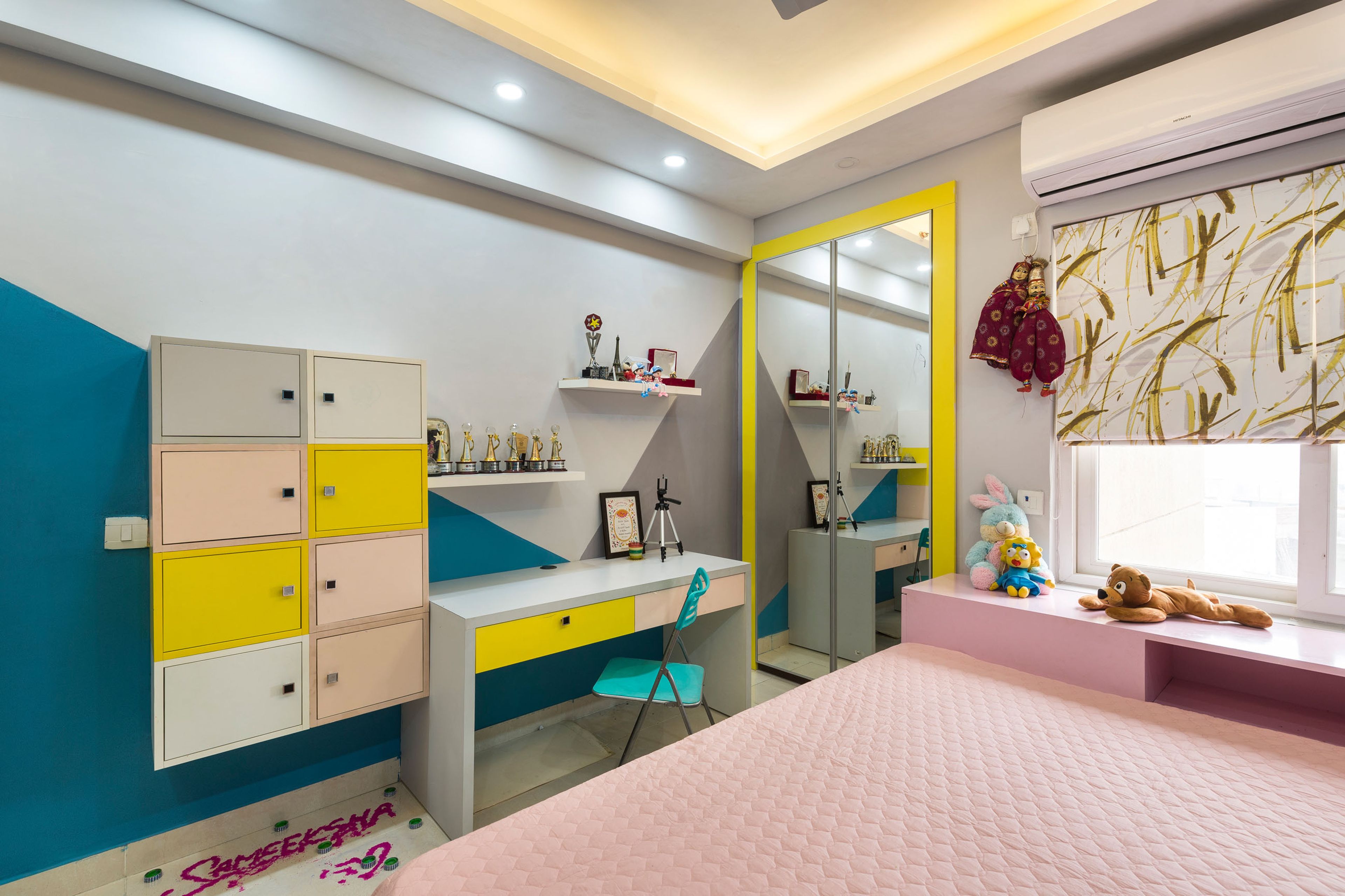 Kids Room With Wall-Mounted Pastel-Toned Storage Units, Study Table And Mirrored Swing Wardrobe - Livspace