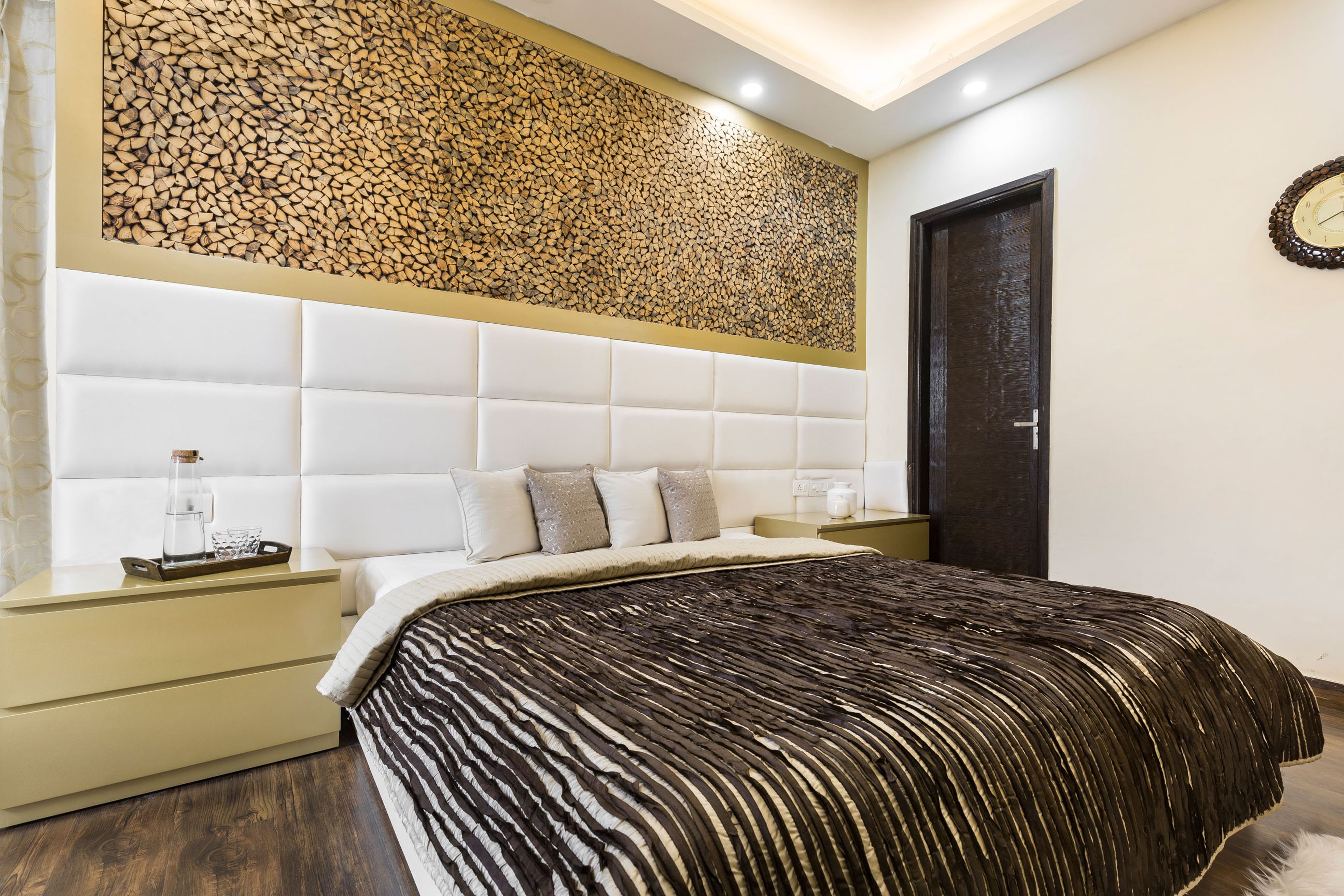 Master Bedroom With Quilted White Accent Wall And Stacked Wood - Livspace