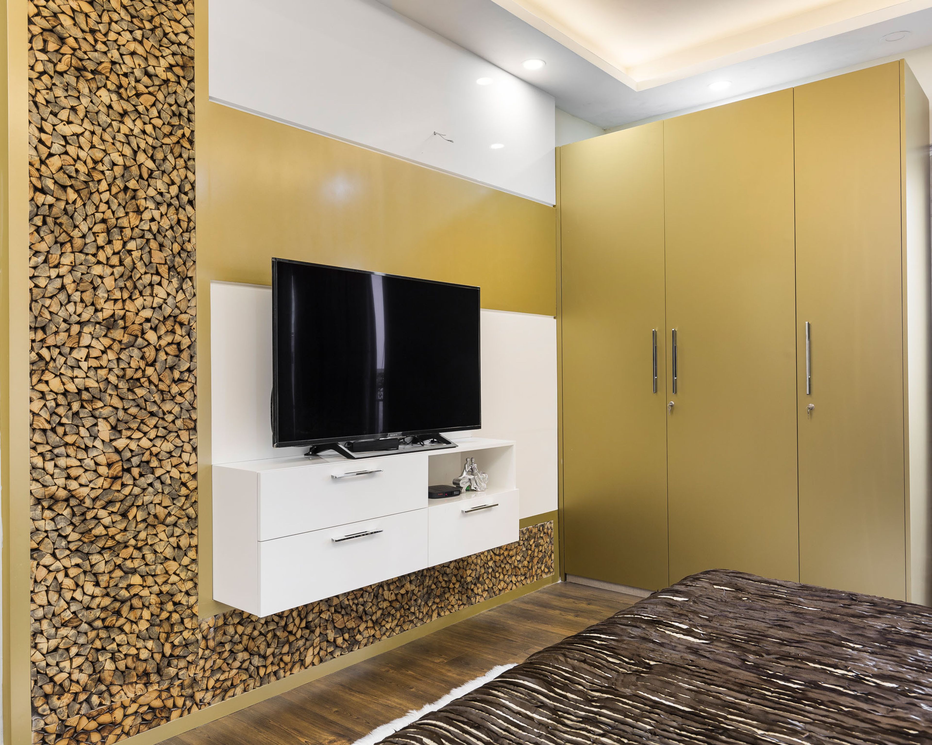 Master Bedroom TV Unit With Stacked Wood Wall Panel And 3-Door Mustard Yellow Swing Wardrobe - Livspace