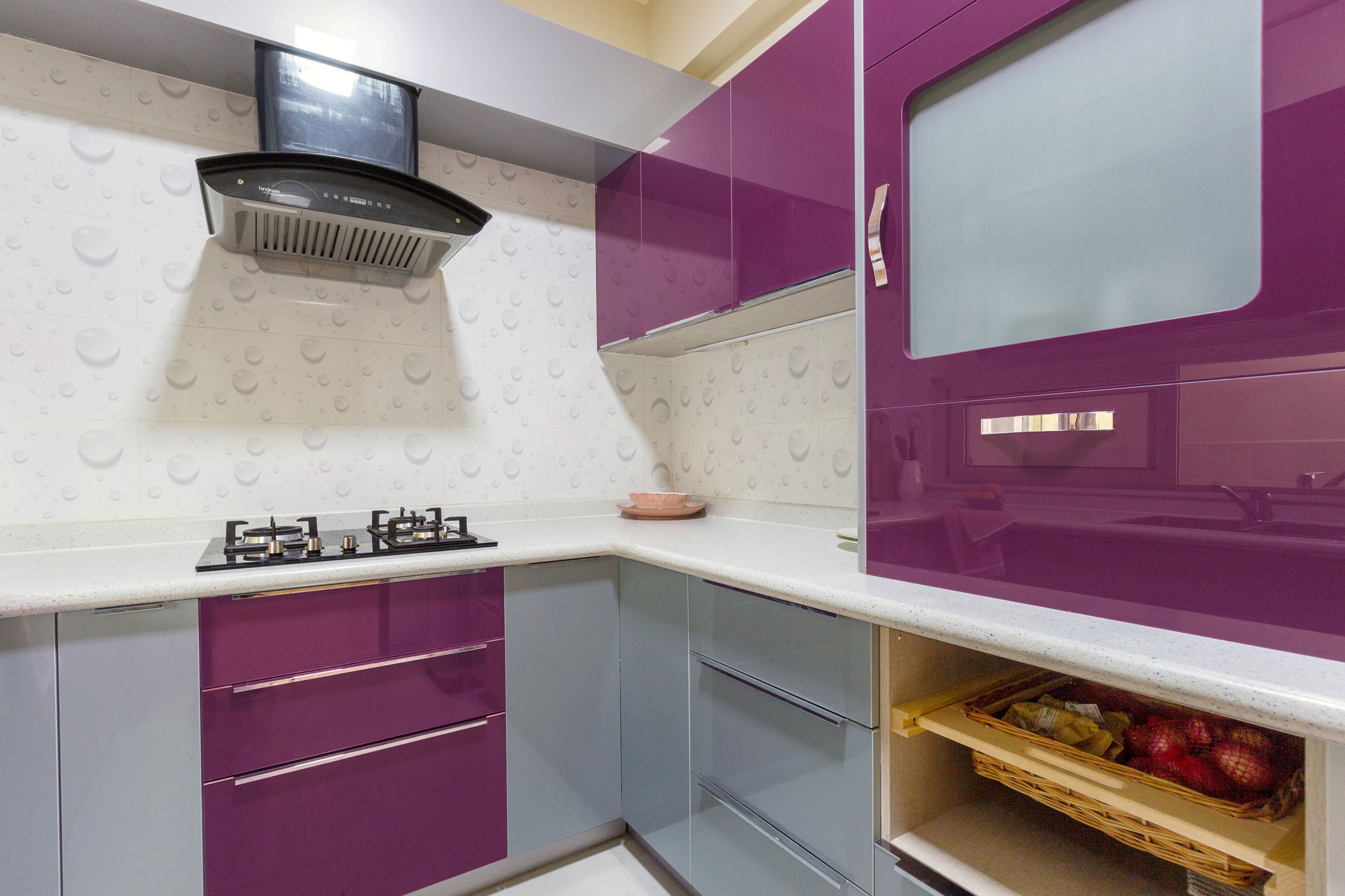 L Shaped Kitchen With Purple And Grey Cabinets, Wicker Basket And Water-Themed Backsplash - Livspace