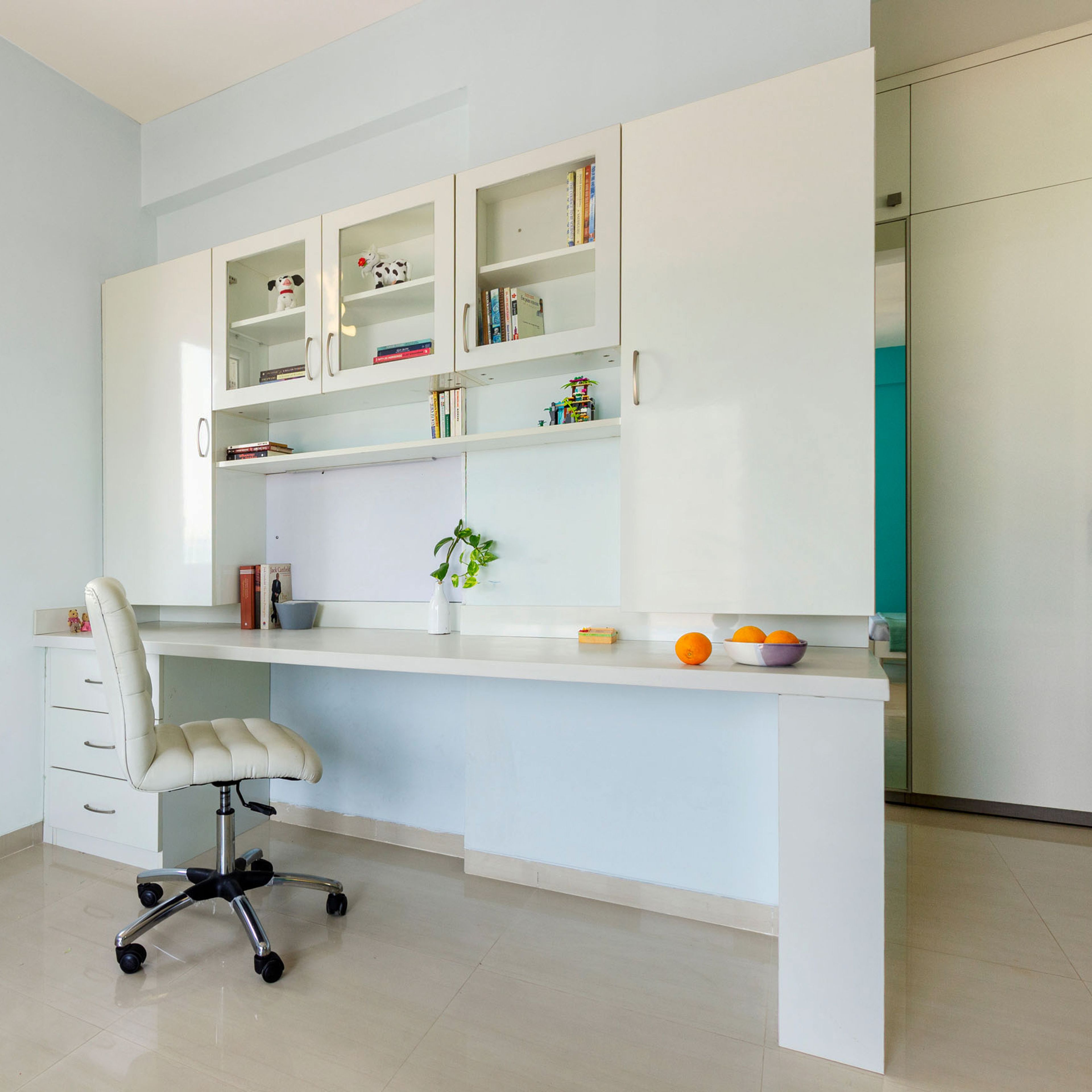 Spacious White Study Table With White Swivel Chair And Cabinet Storage - Livspace