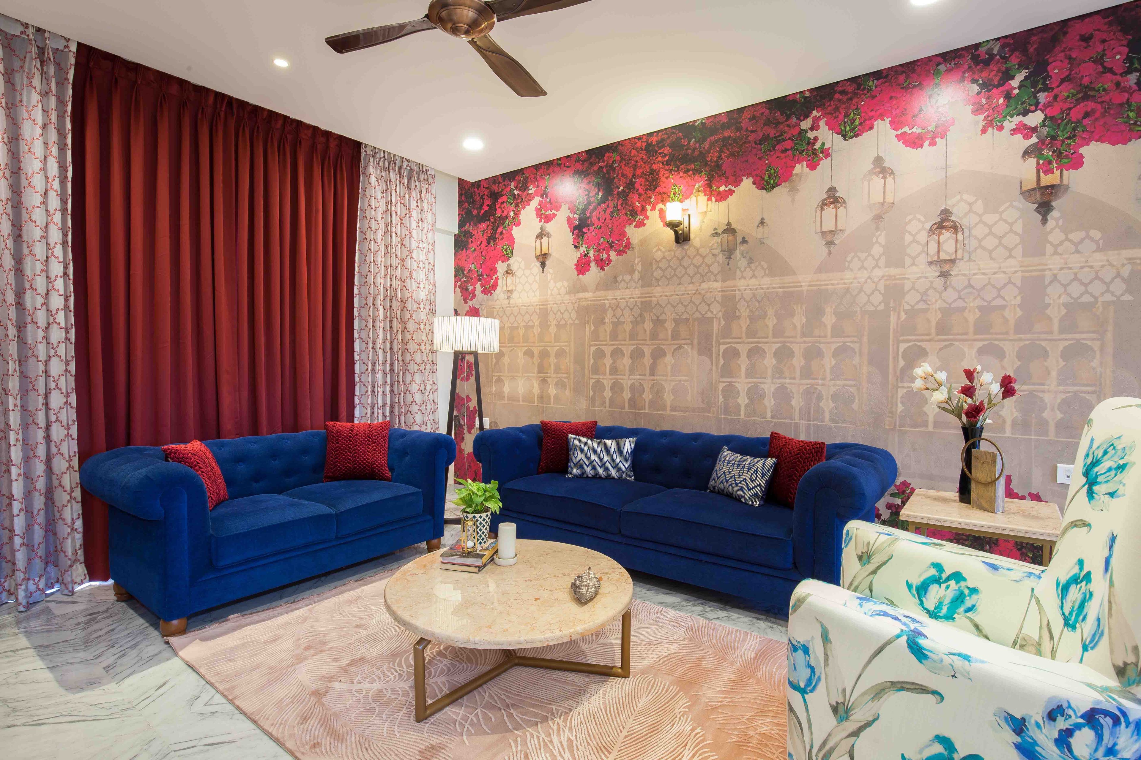 Living Room With Dark Blue Sofa, Transitional Floral Wallpaper And Patterned Floral Chair - Livspace