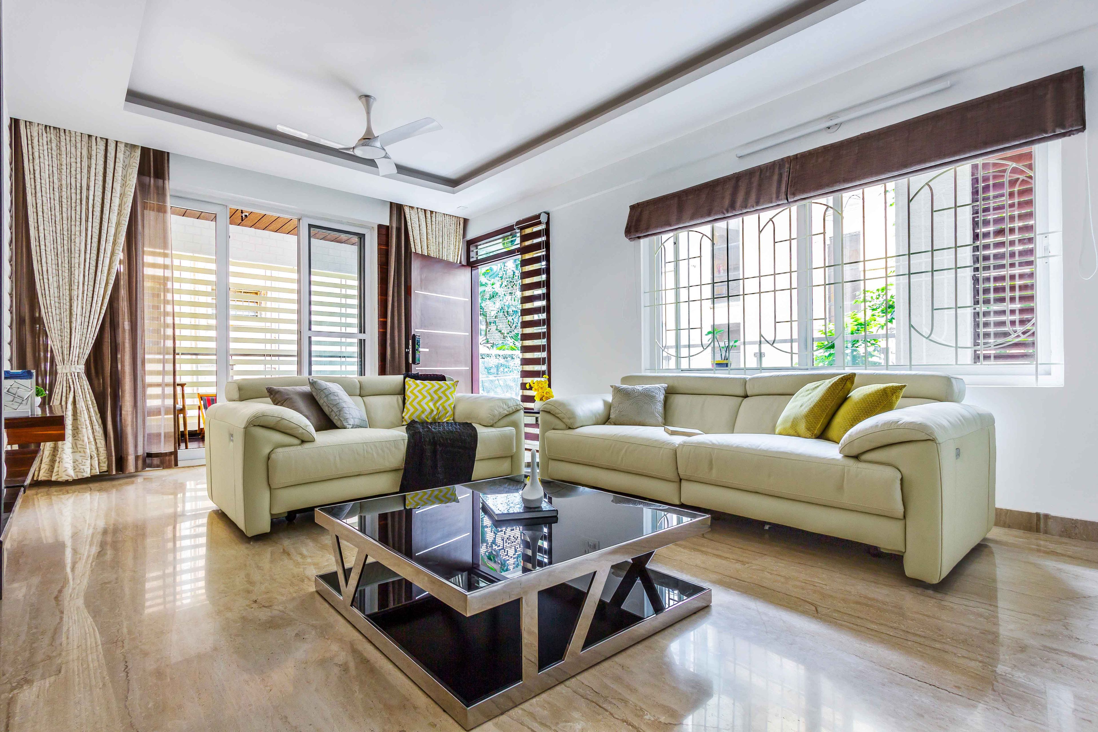 Spacious Living Room With Beige Sofa and Black Square Coffee Table - Livspace