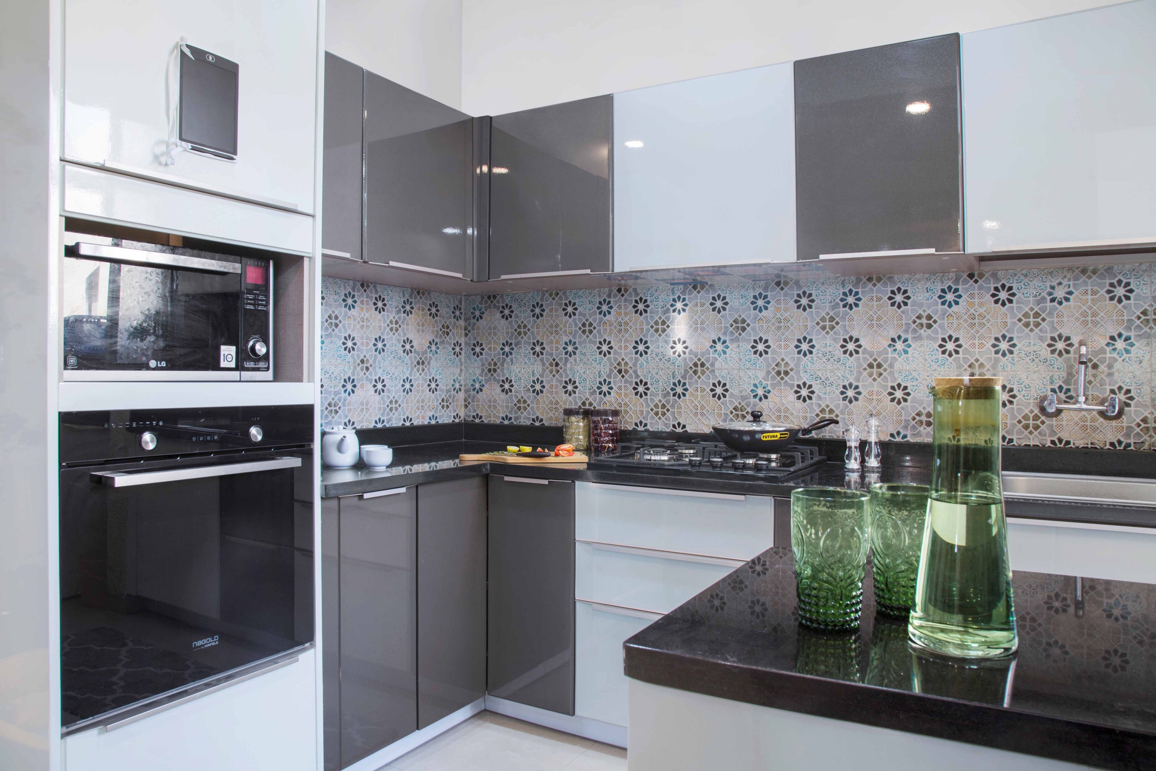 Grey And White L Shaped Modular Kitchen With White Appliance Unit And Moroccan Dado Tiles - Livspace