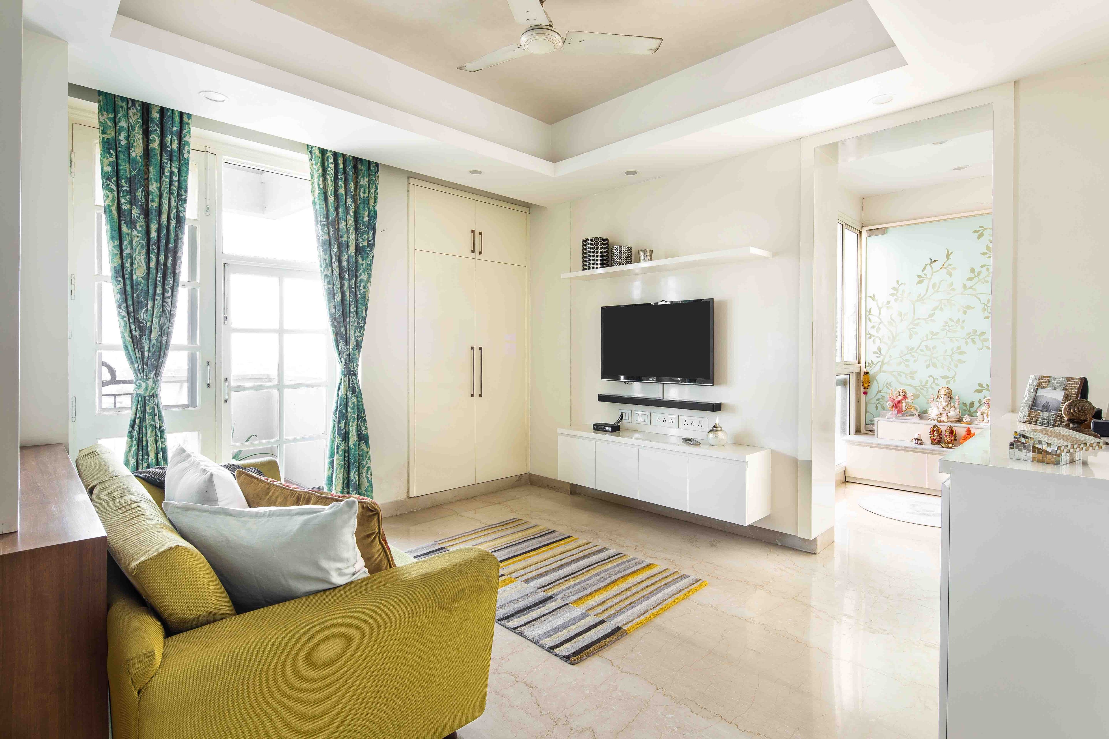 Spacious Living Room With Yellow 2-Seater And White Wall-Mounted TV Unit - Livspace