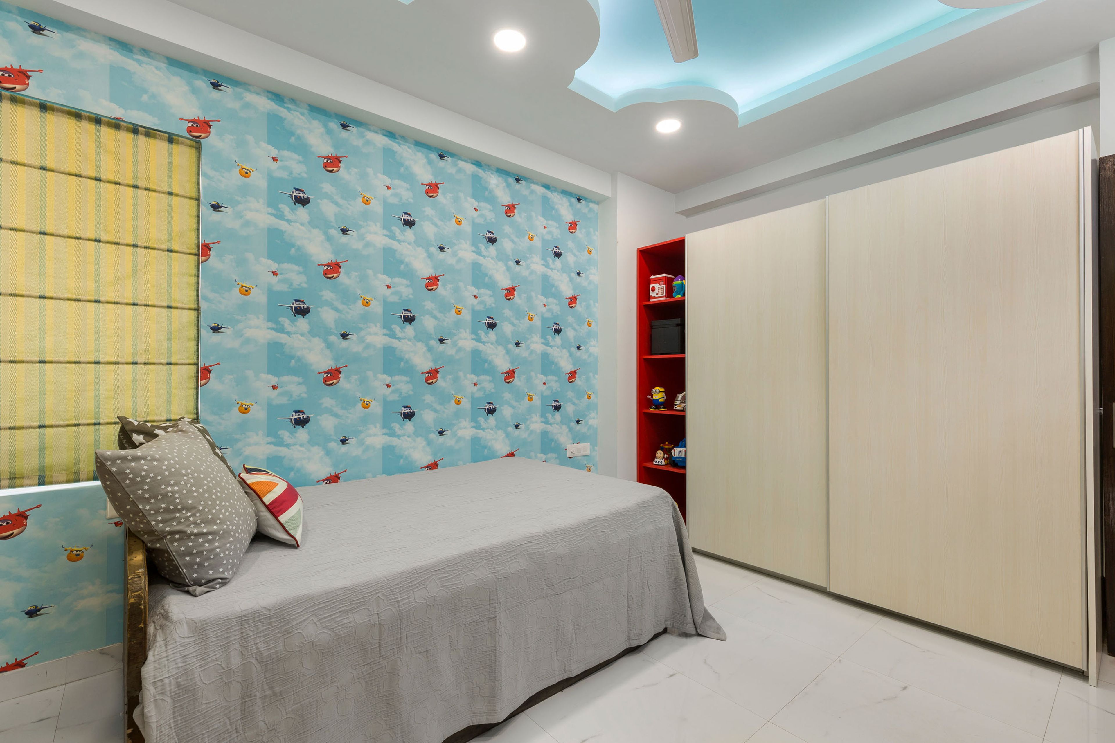 Kids Room Design With Single Bed, Helicopter-Themed Wallpaper And 2-Door Wooden Sliding Wardrobe With Red Storage - Livspace