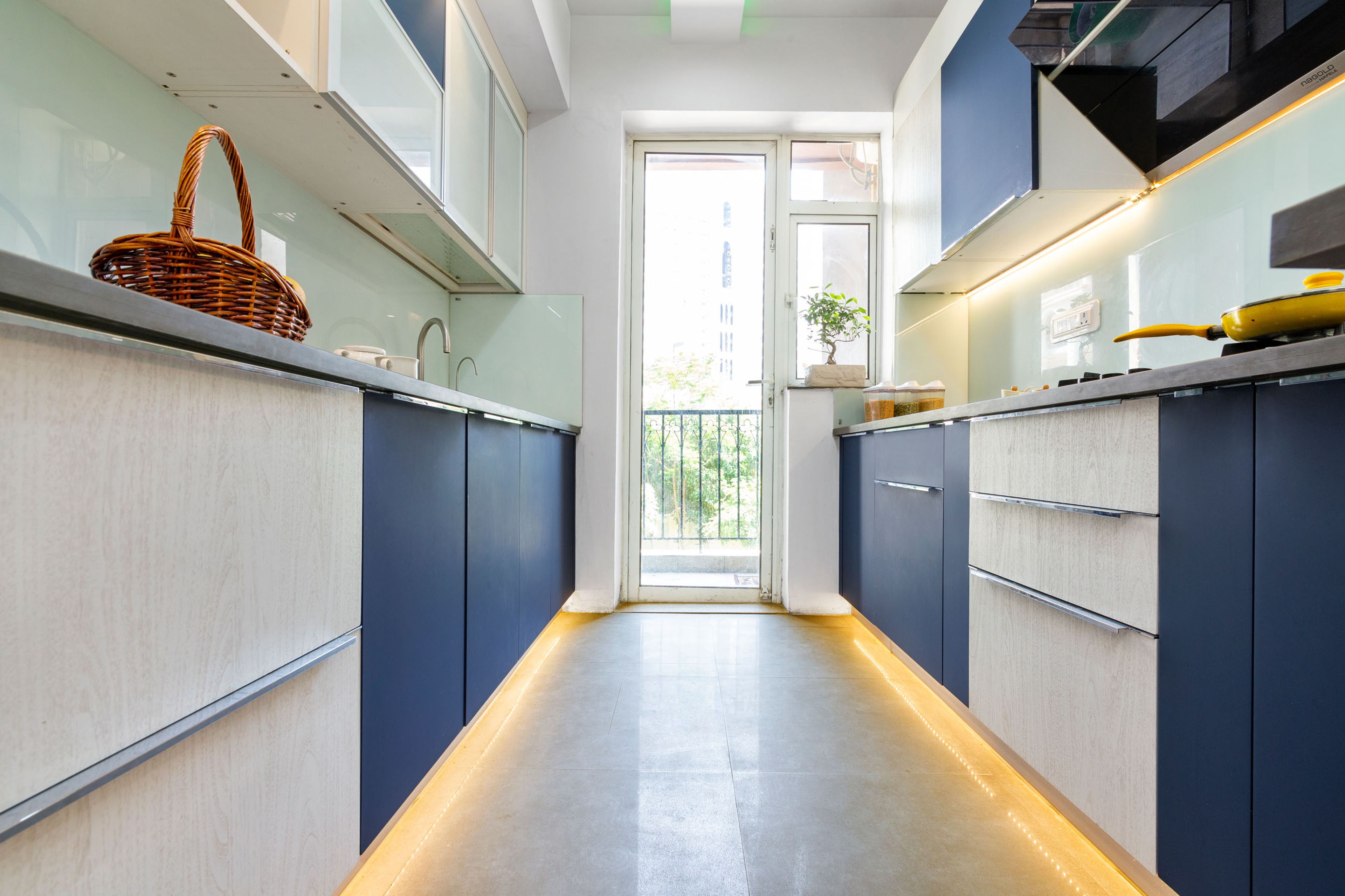 Contemporary 2-BHK Flat Design In Gurgaon With Blue And Light Wood Parallel Modular Kitchen