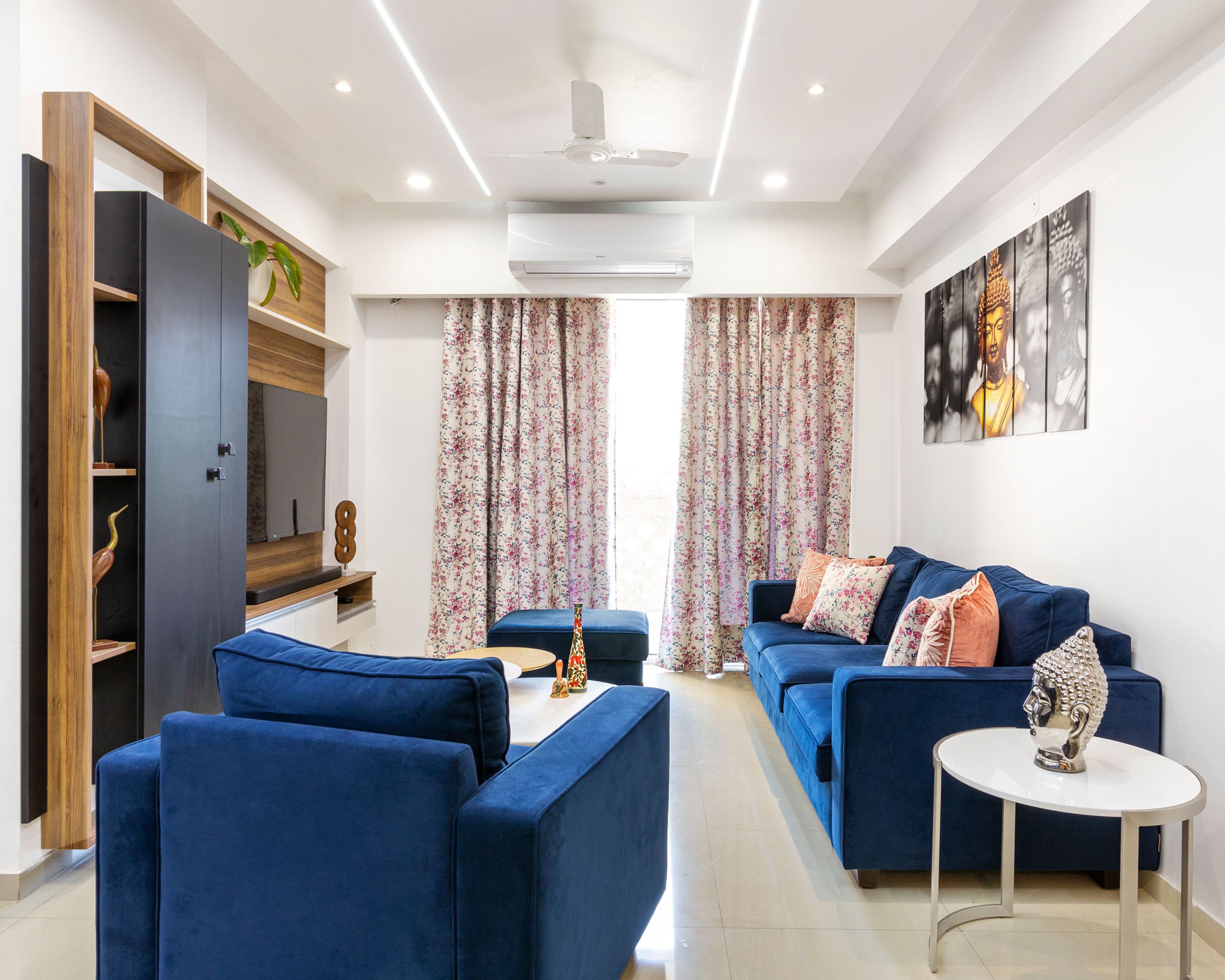 Spacious Living Room Design With 3-Seater Blue Sofa And Accent Chair, Nesting Table, White-Wood And Black TV Console WIth Storage Unit - Livspace